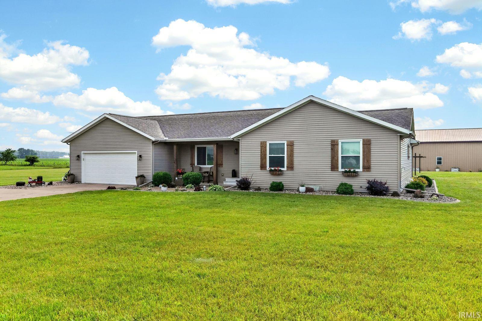 Ranch-style residence featuring light gray siding and a dark shingled roof
