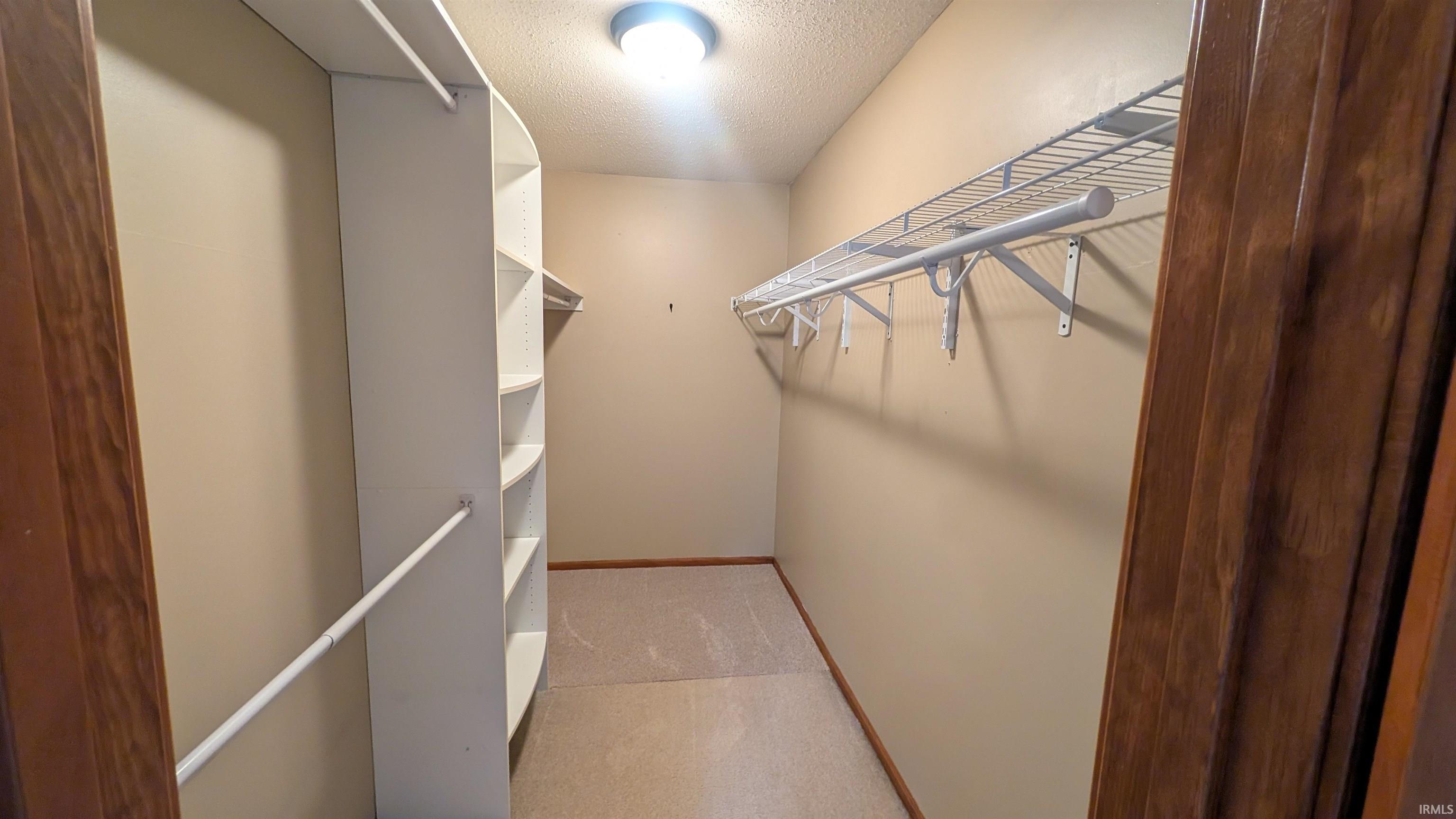 Walk-in closet featuring built-in shelving, wire racking, and a clothing rod