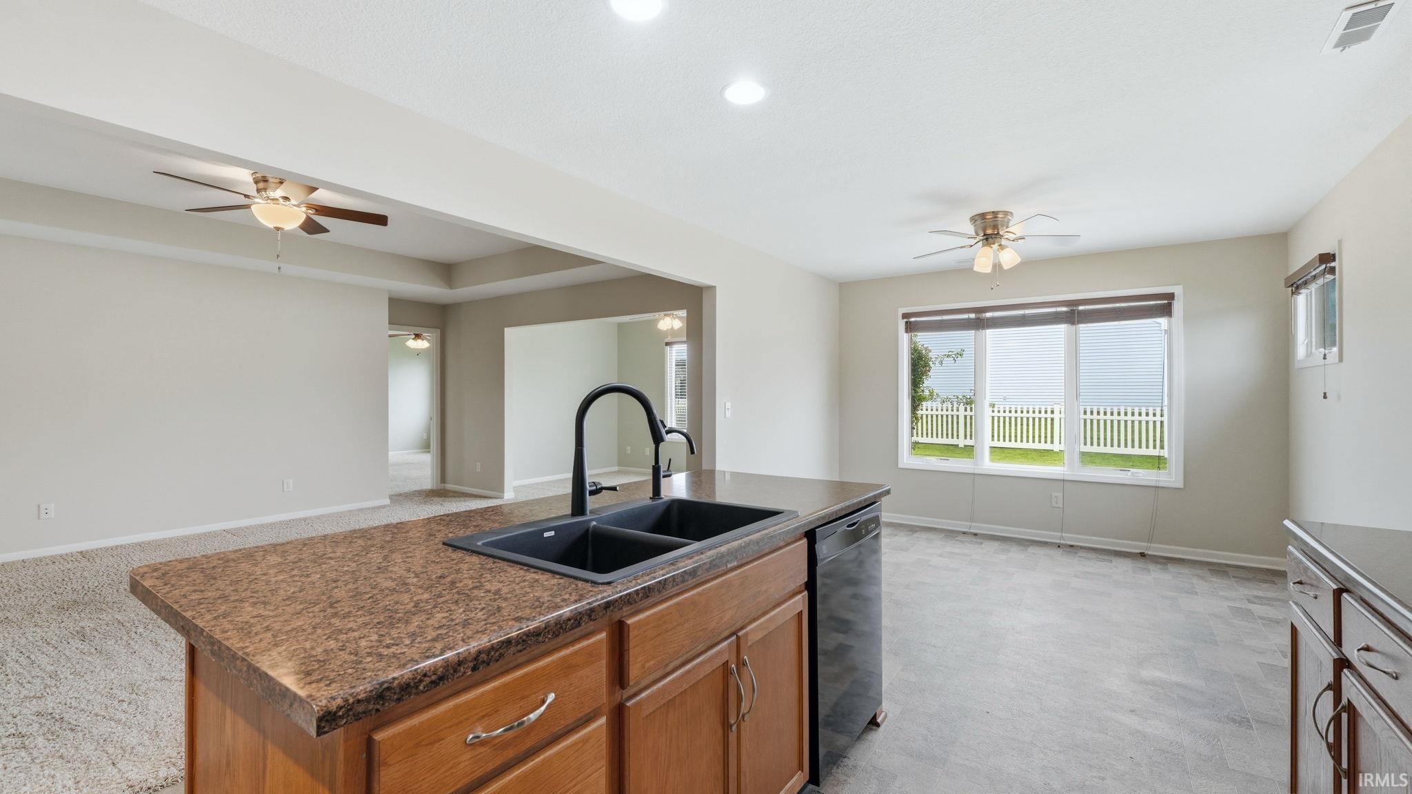 Kitchen island with an undermount double-basin sink and a matte black gooseneck faucet