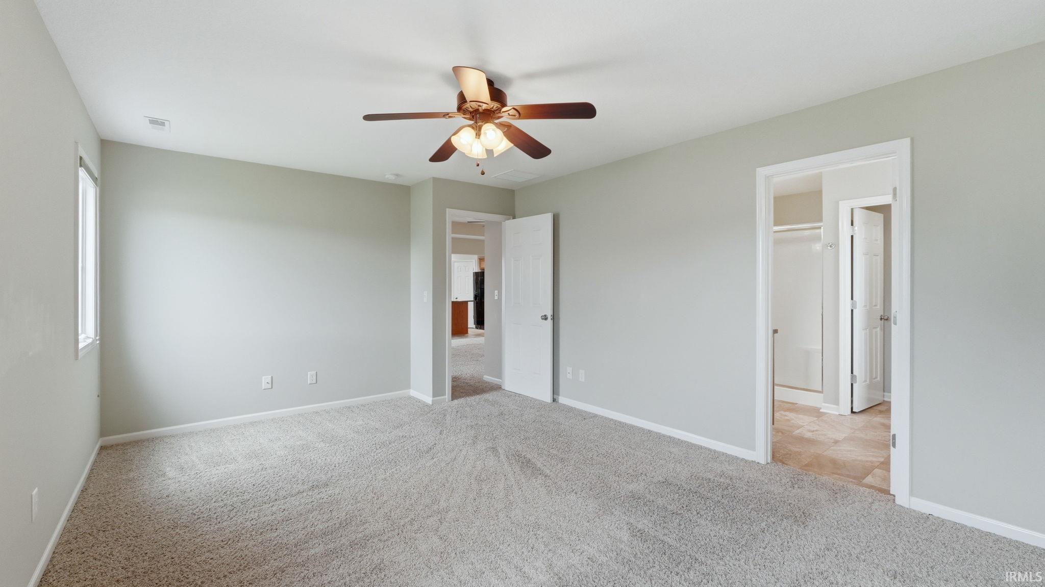 Carpeted room with light gray walls, a window, and white trim