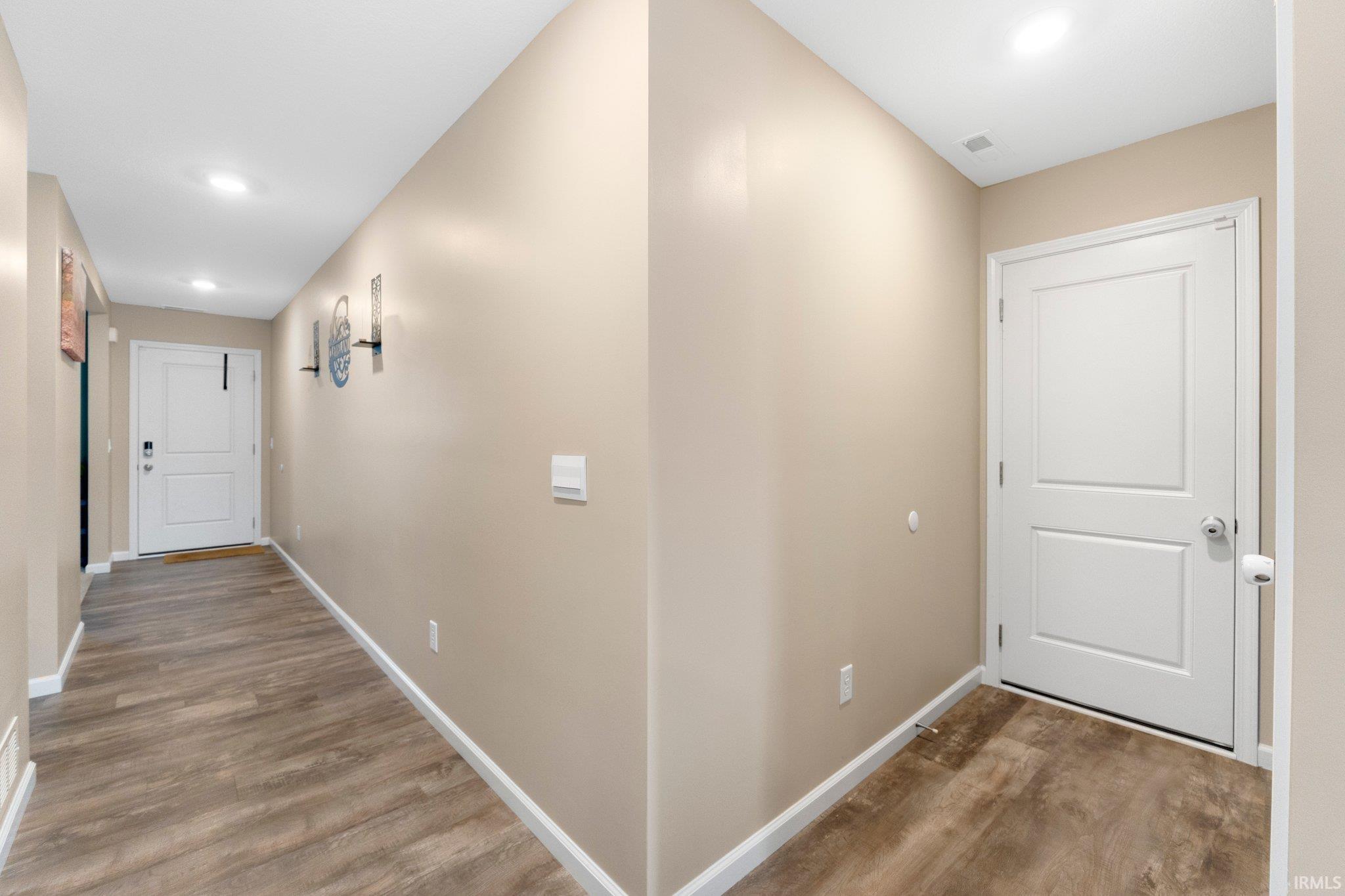 Hallway featuring wood-finish flooring, recessed lighting, and neutral wall tones