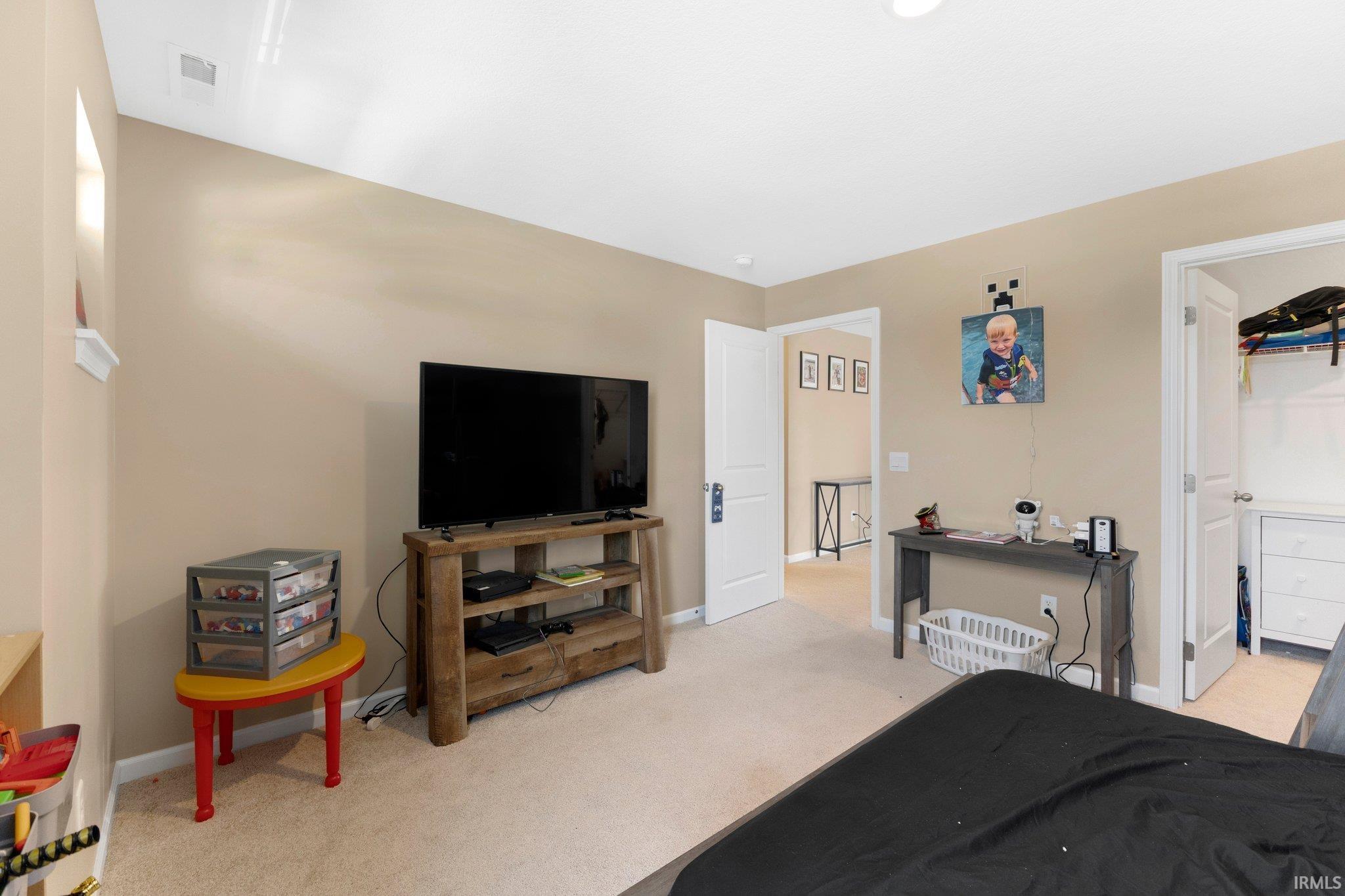 Carpeted room featuring a built-in recessed window niche, a white ceiling, and two interior doorways