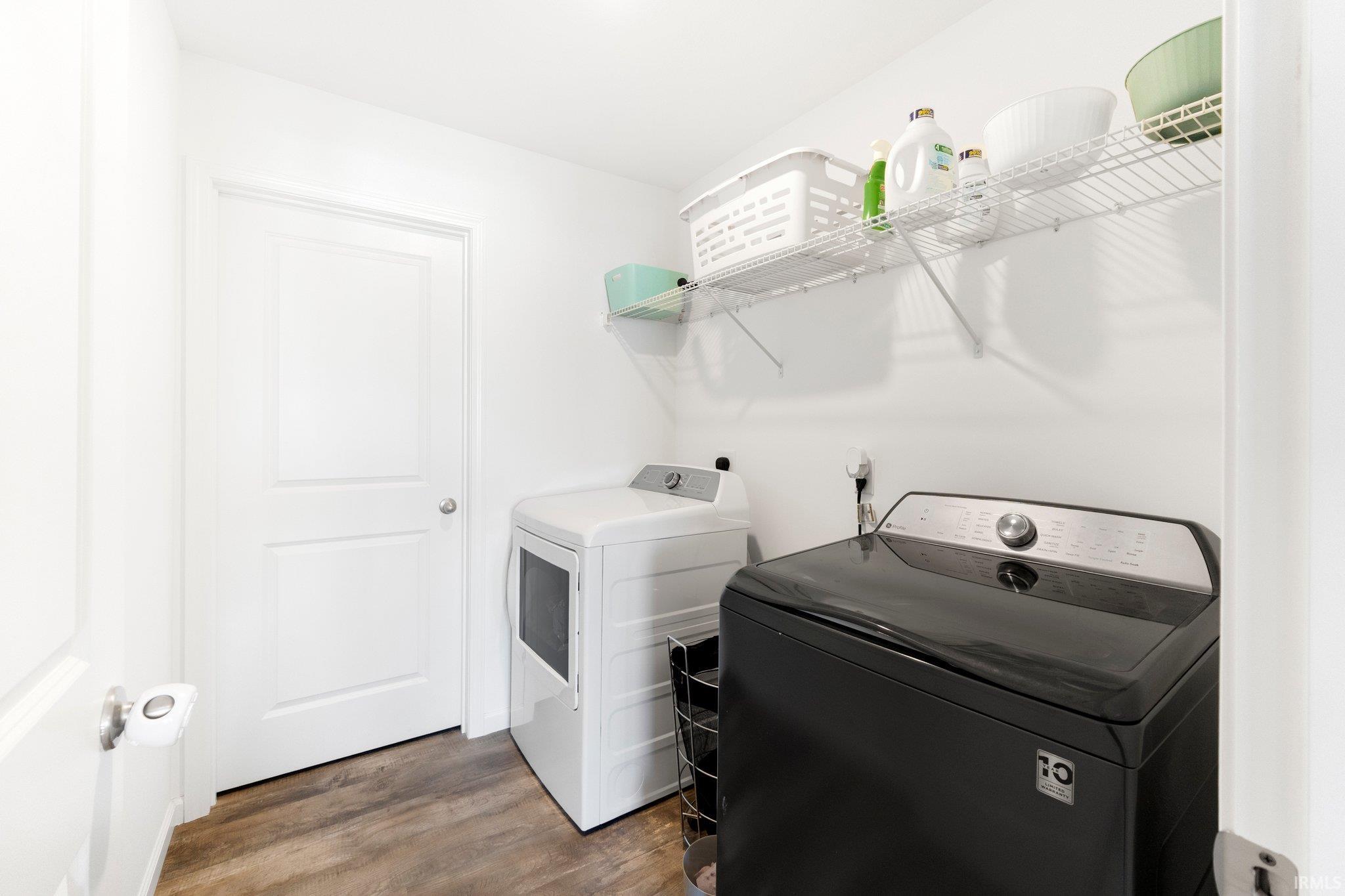 Dedicated laundry area featuring wood-finish flooring and bright white walls