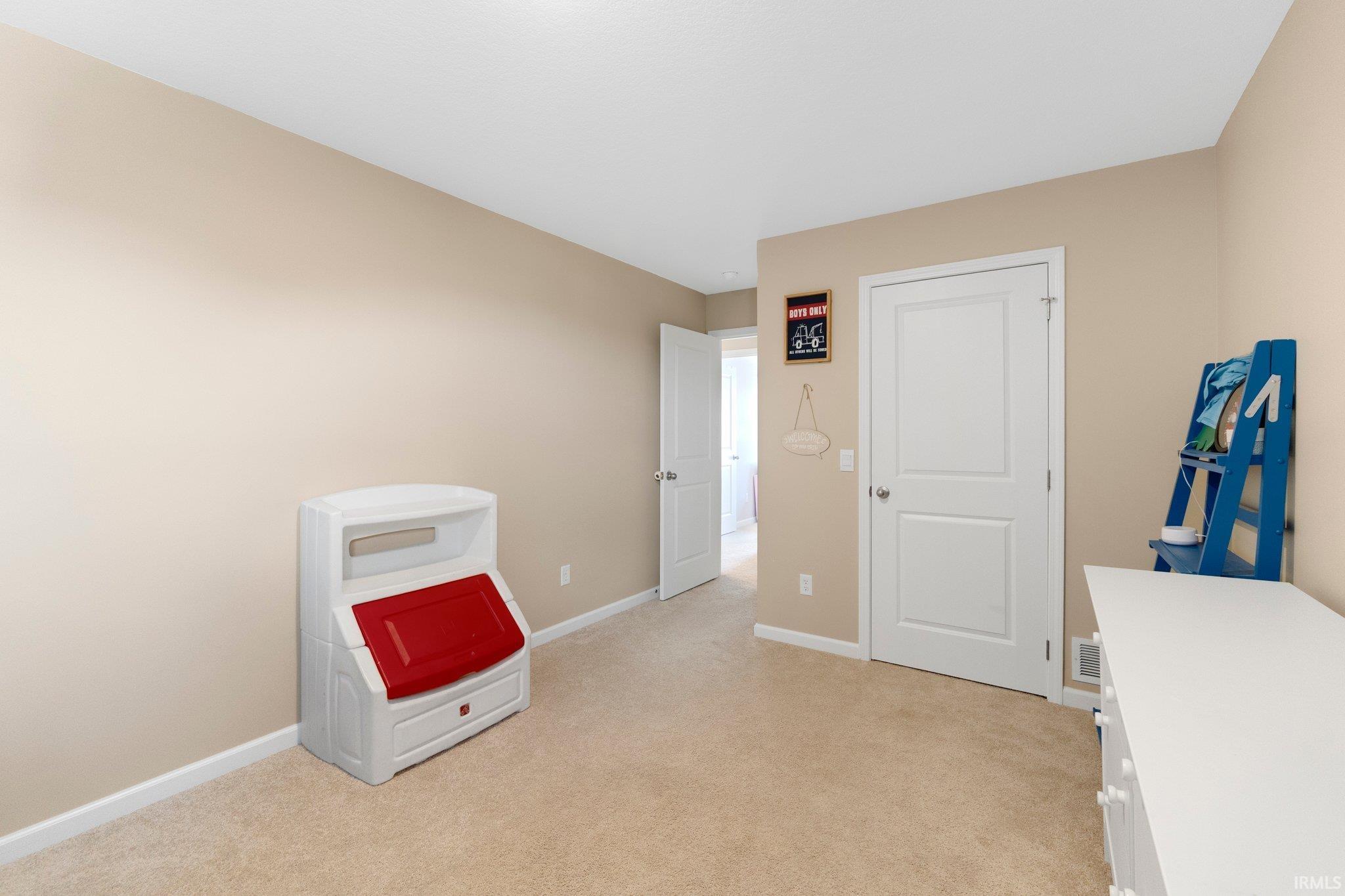 Carpeted room with neutral wall tones and white trim