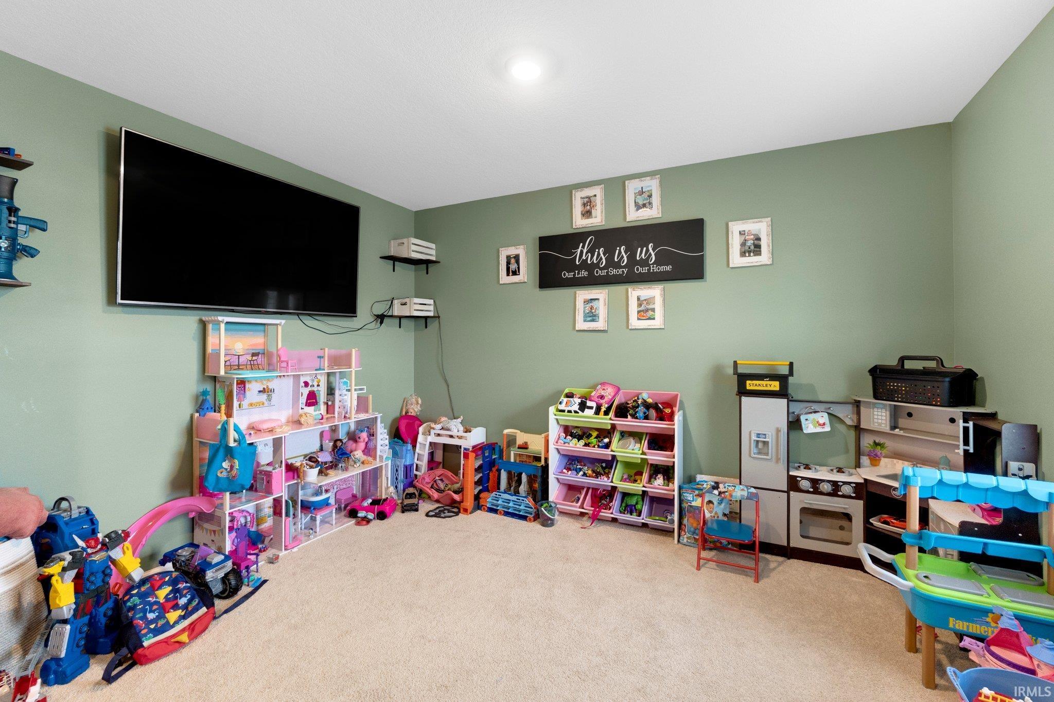 Spacious room featuring light green walls and plush carpeting