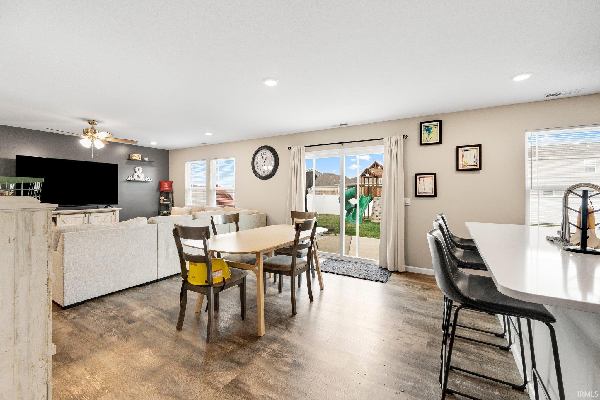 Open-concept living area featuring wood-finish flooring, recessed lighting, and a neutral color palette