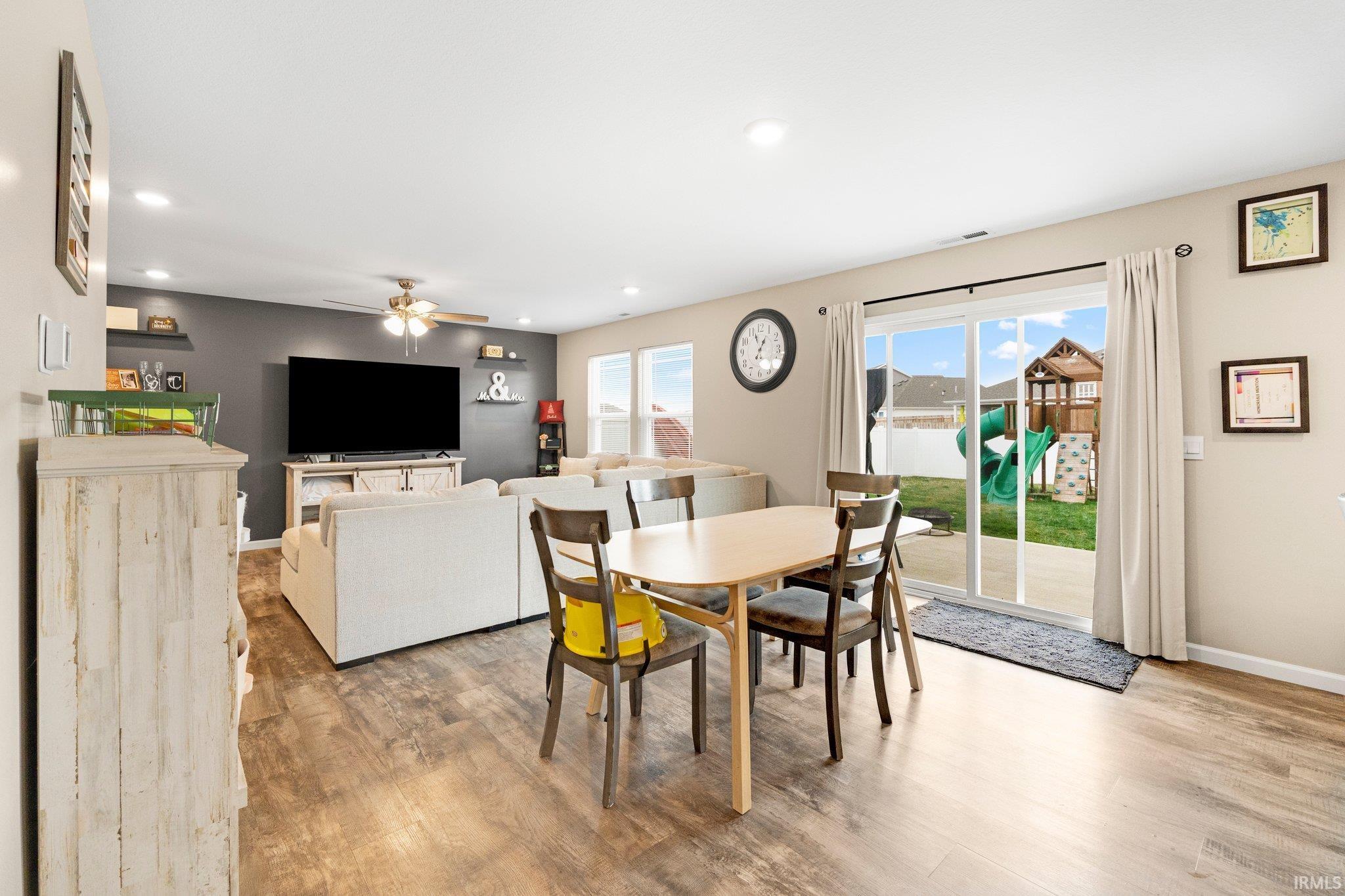 Open-concept living area with wood-finish flooring, recessed lighting, and a ceiling fan