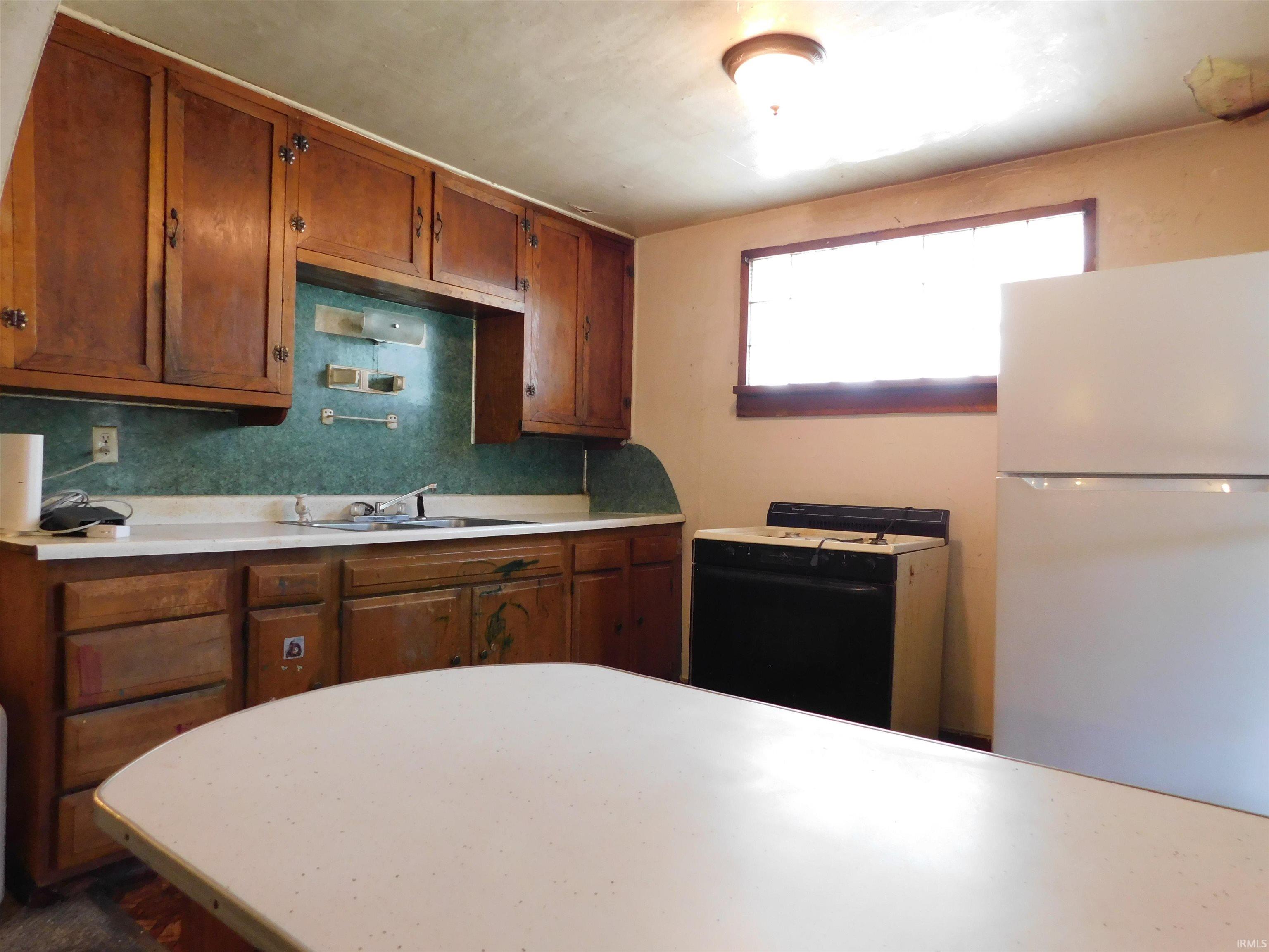Kitchen featuring wood cabinetry, white countertops, and a white built-in refrigerator