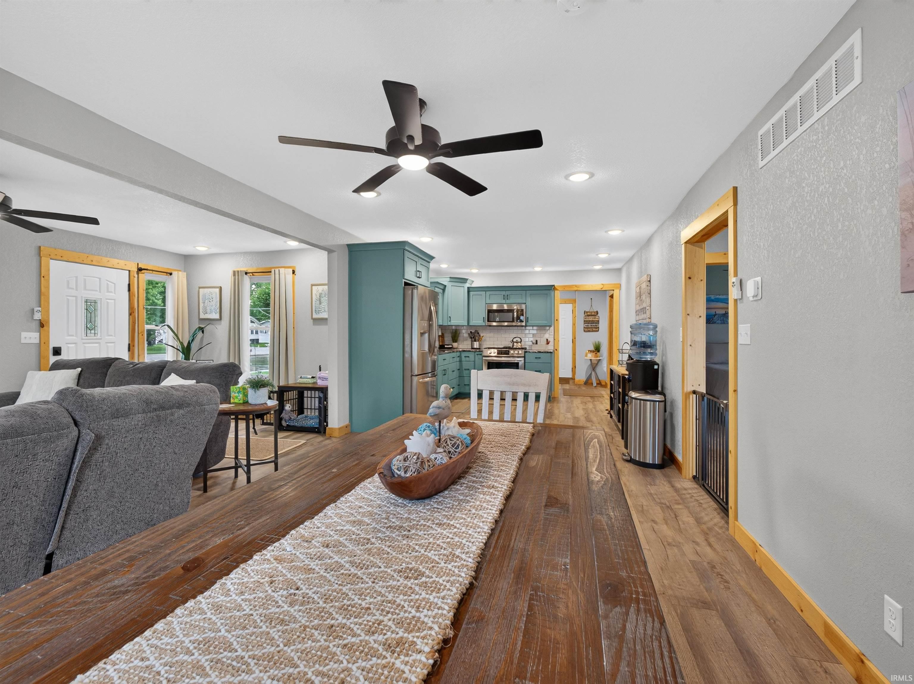 Open-concept living area featuring wood-finish flooring, recessed lighting, and ceiling fans