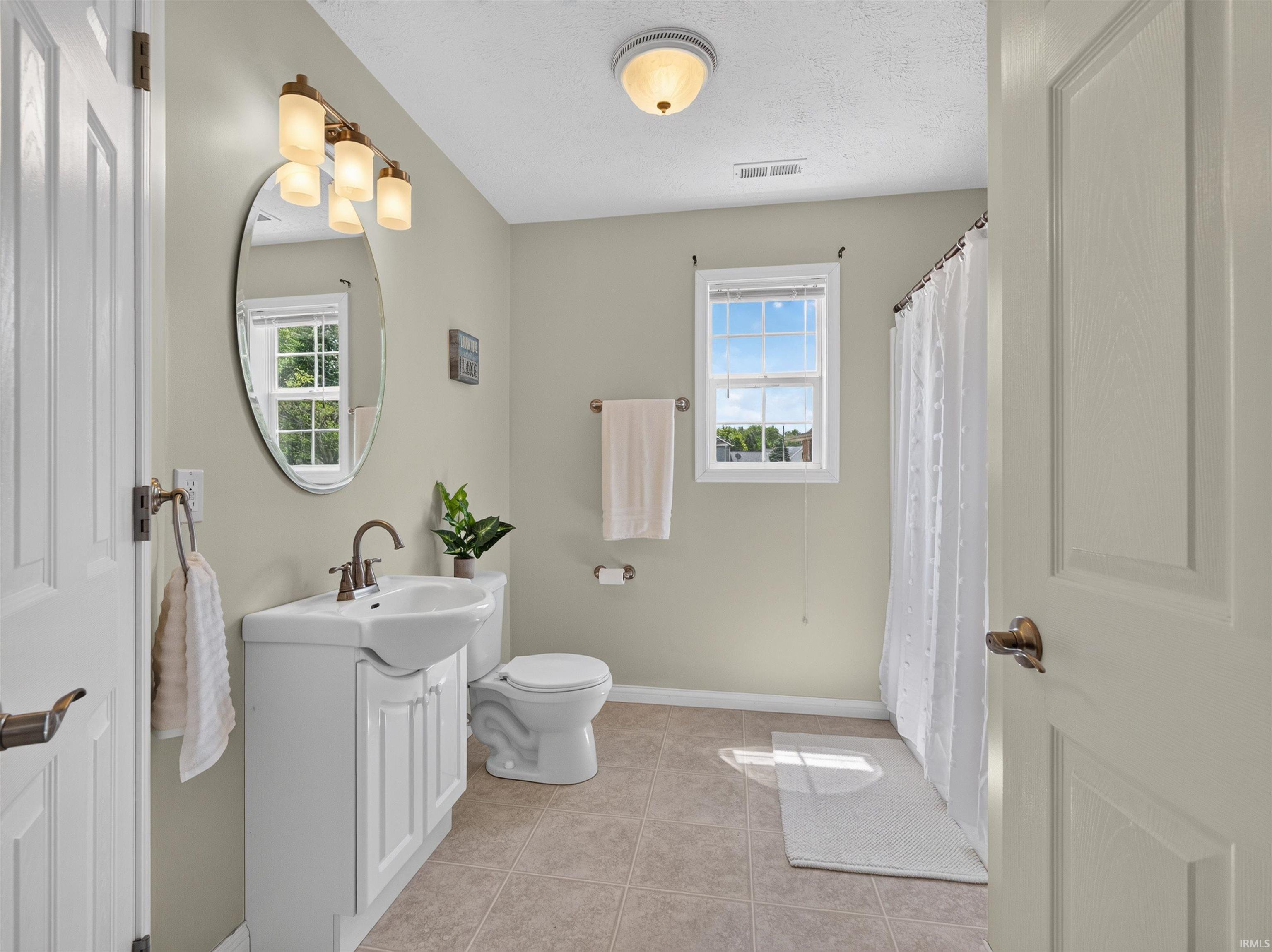 Full bathroom featuring a single vanity, a toilet, and a shower area