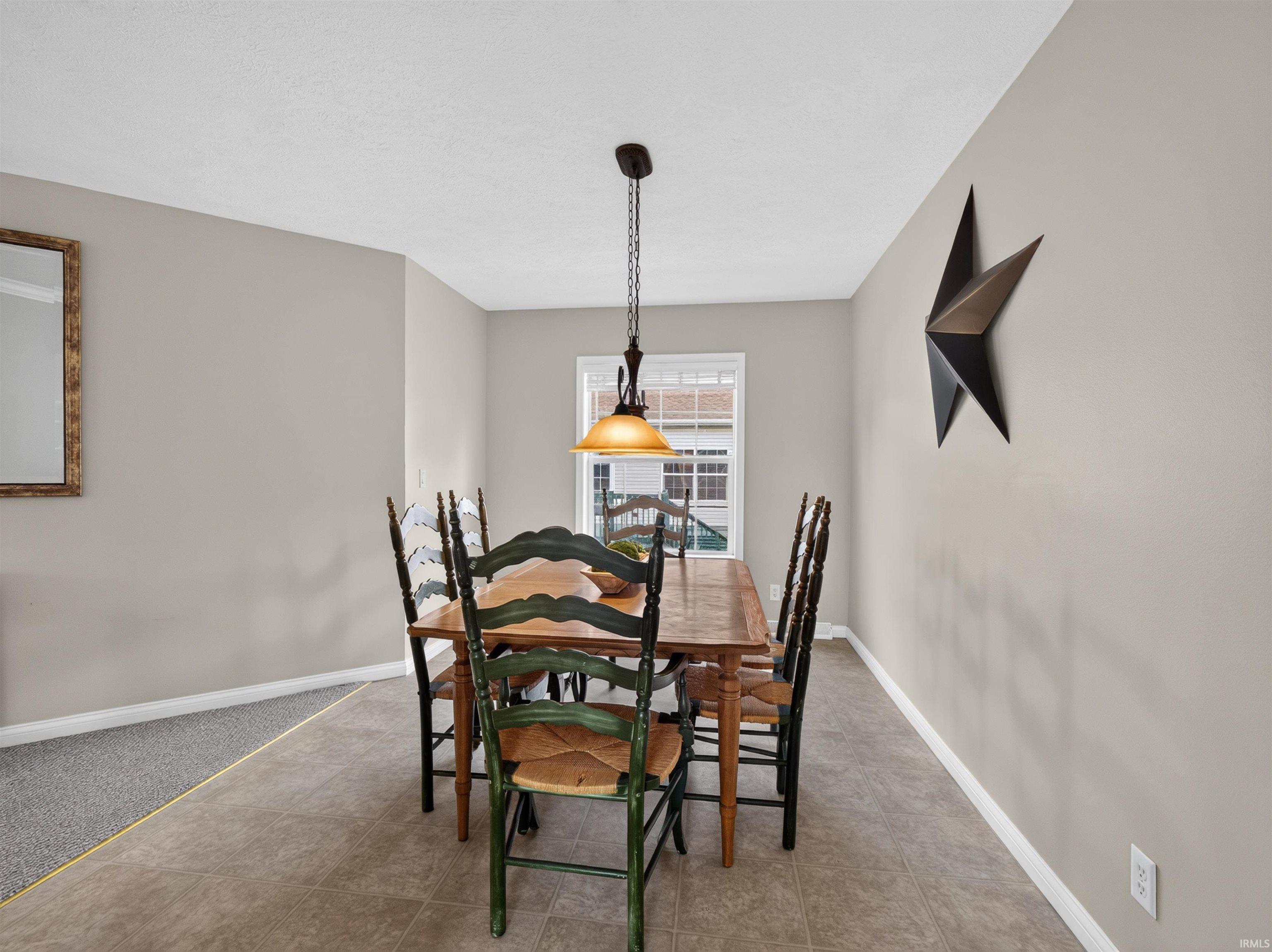 Dining area featuring neutral wall paint, white trim, a window with natural light, and a ceiling-mounted light fixture