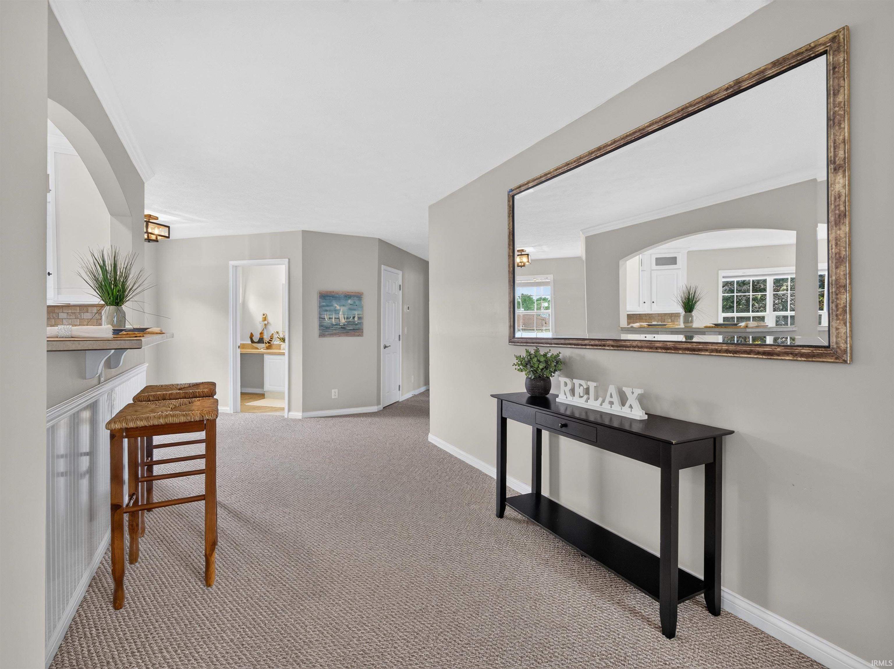Archway entry with recessed lighting, light gray wall tones, and neutral carpet flooring
