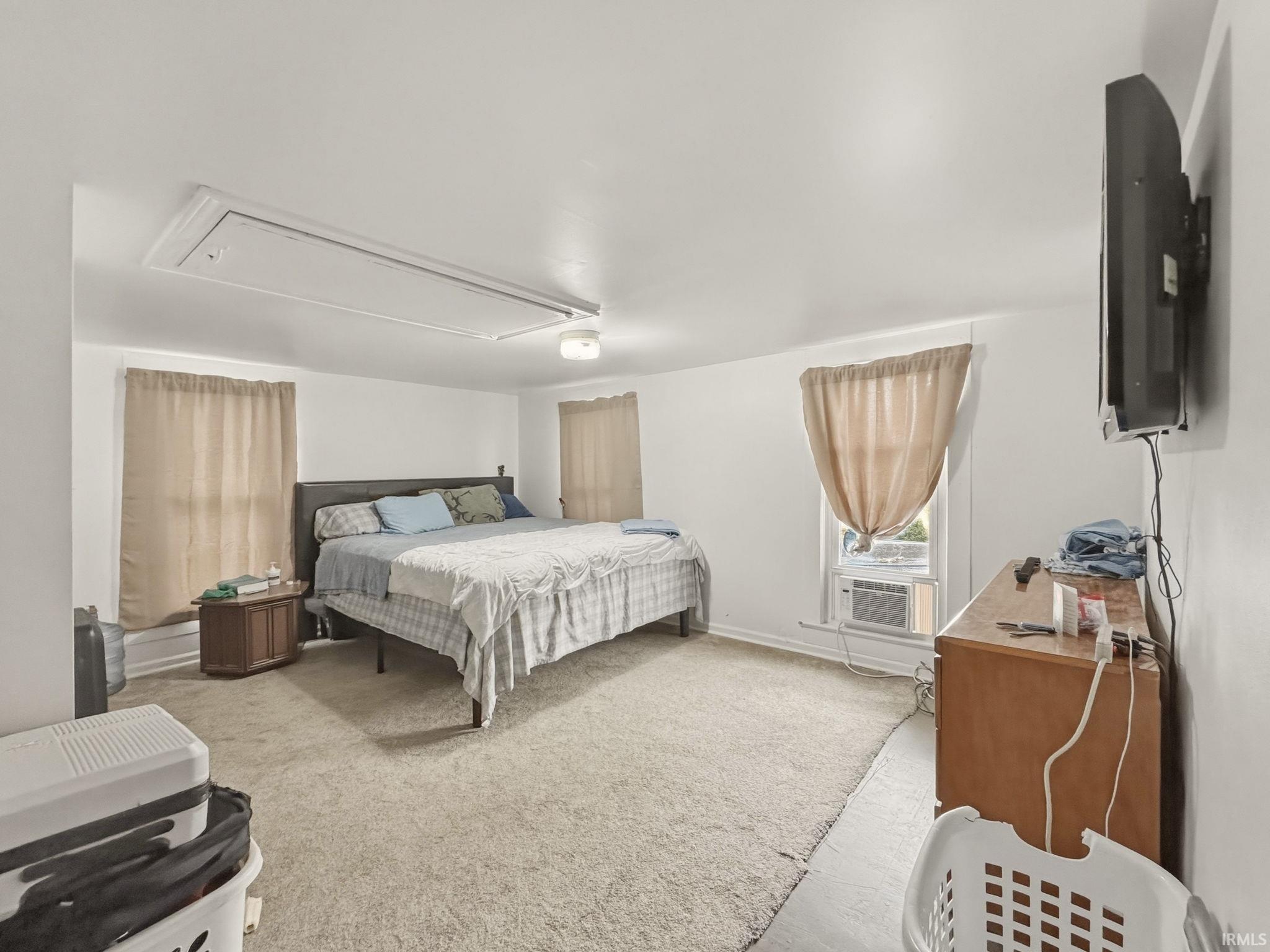 Spacious room featuring neutral carpeting, a ceiling fan, and white painted walls