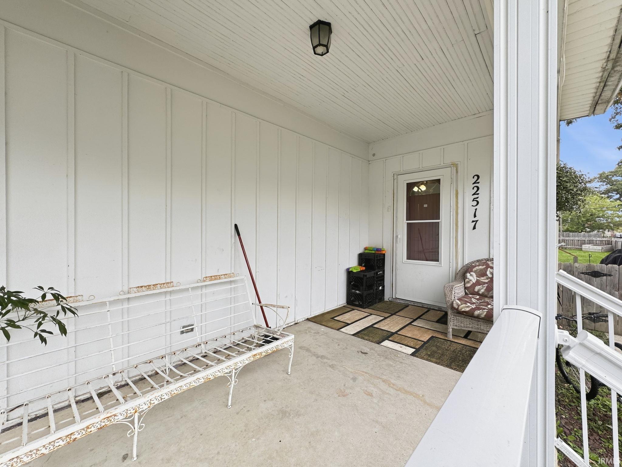 Covered porch entry featuring vertical panel siding