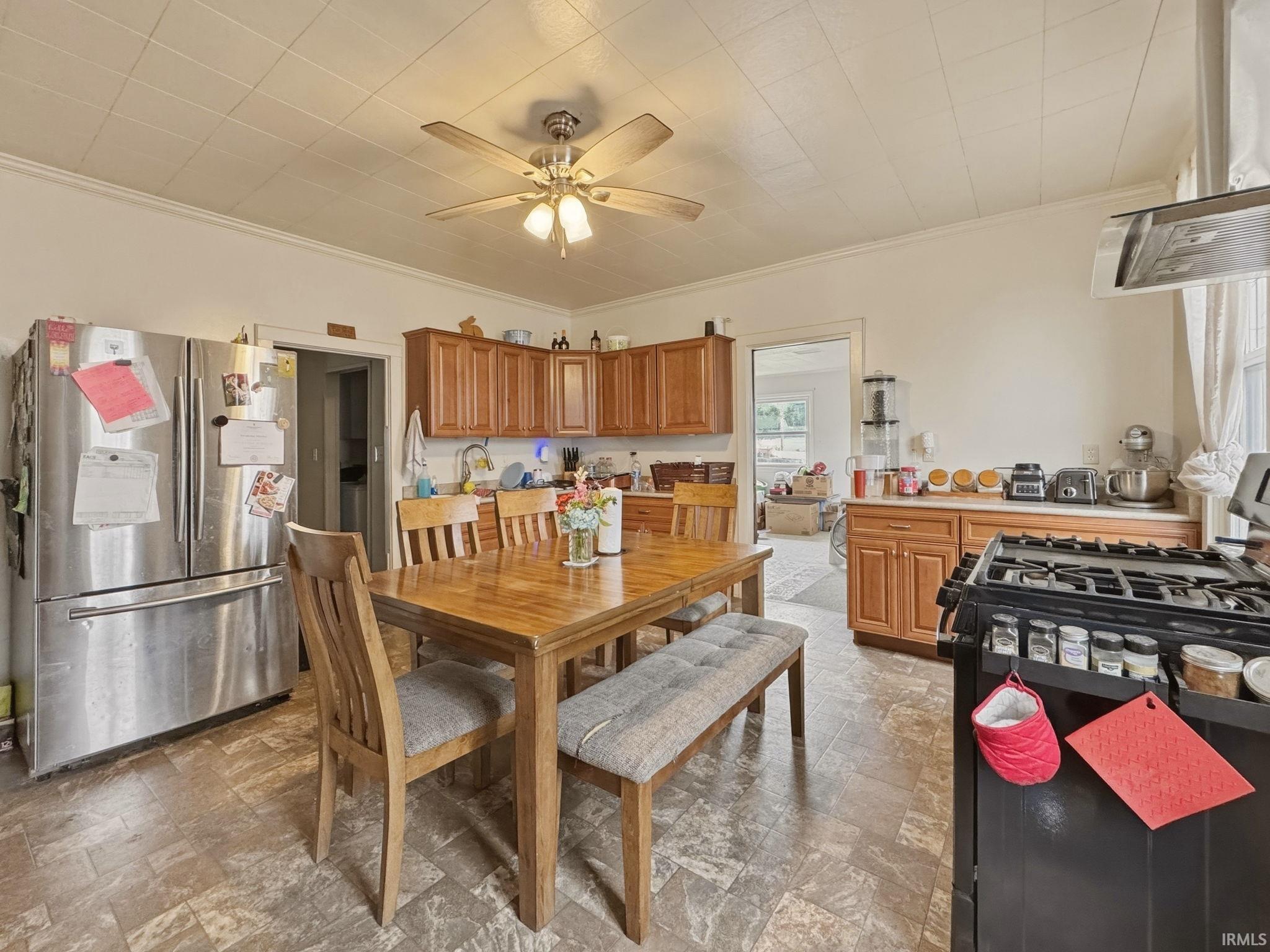 Kitchen featuring wood-finish cabinetry, stainless steel appliances, and a gas range