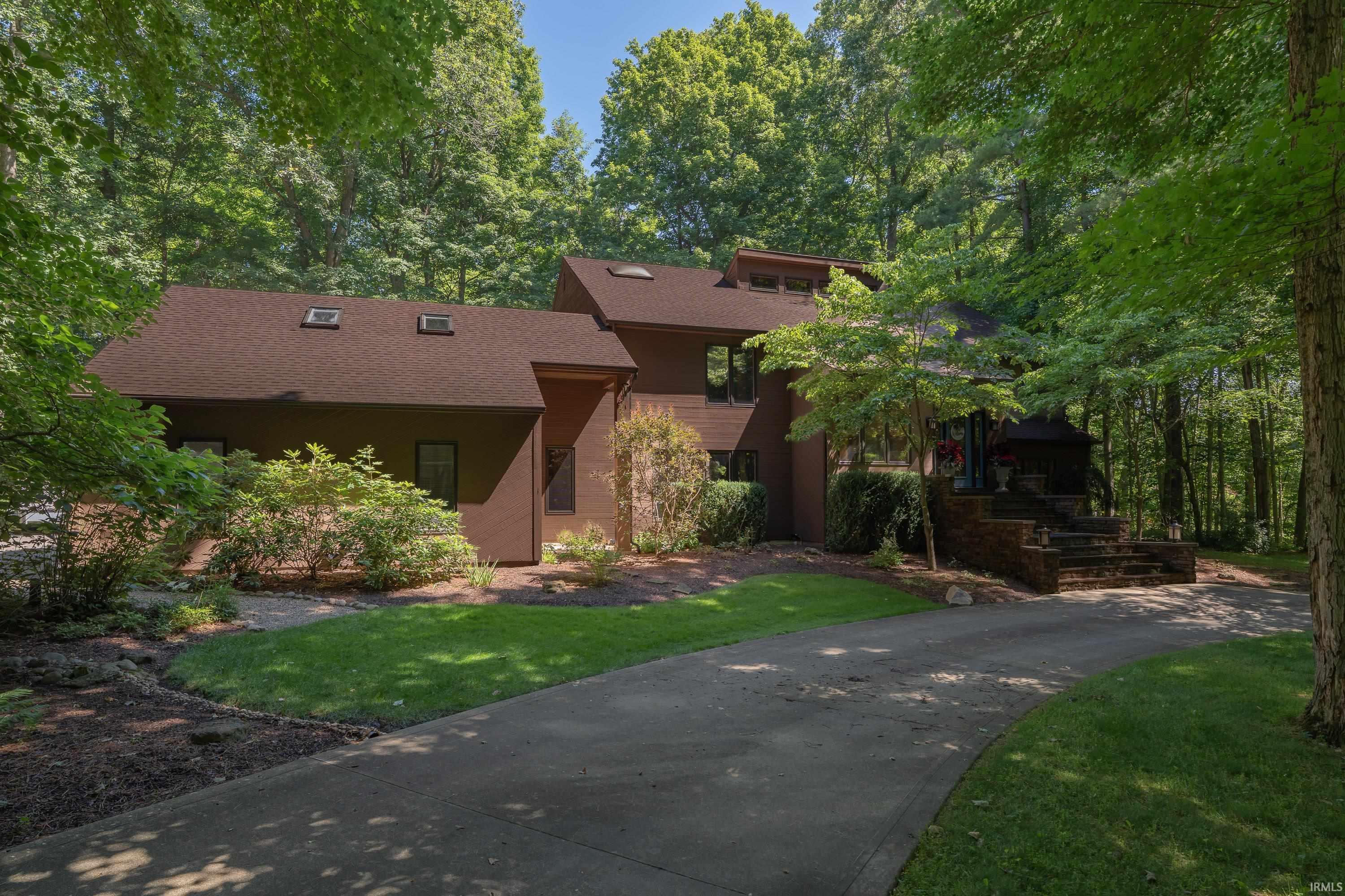 Contemporary multi-level residence with a dark brown exterior and a complementing brown shingle roof