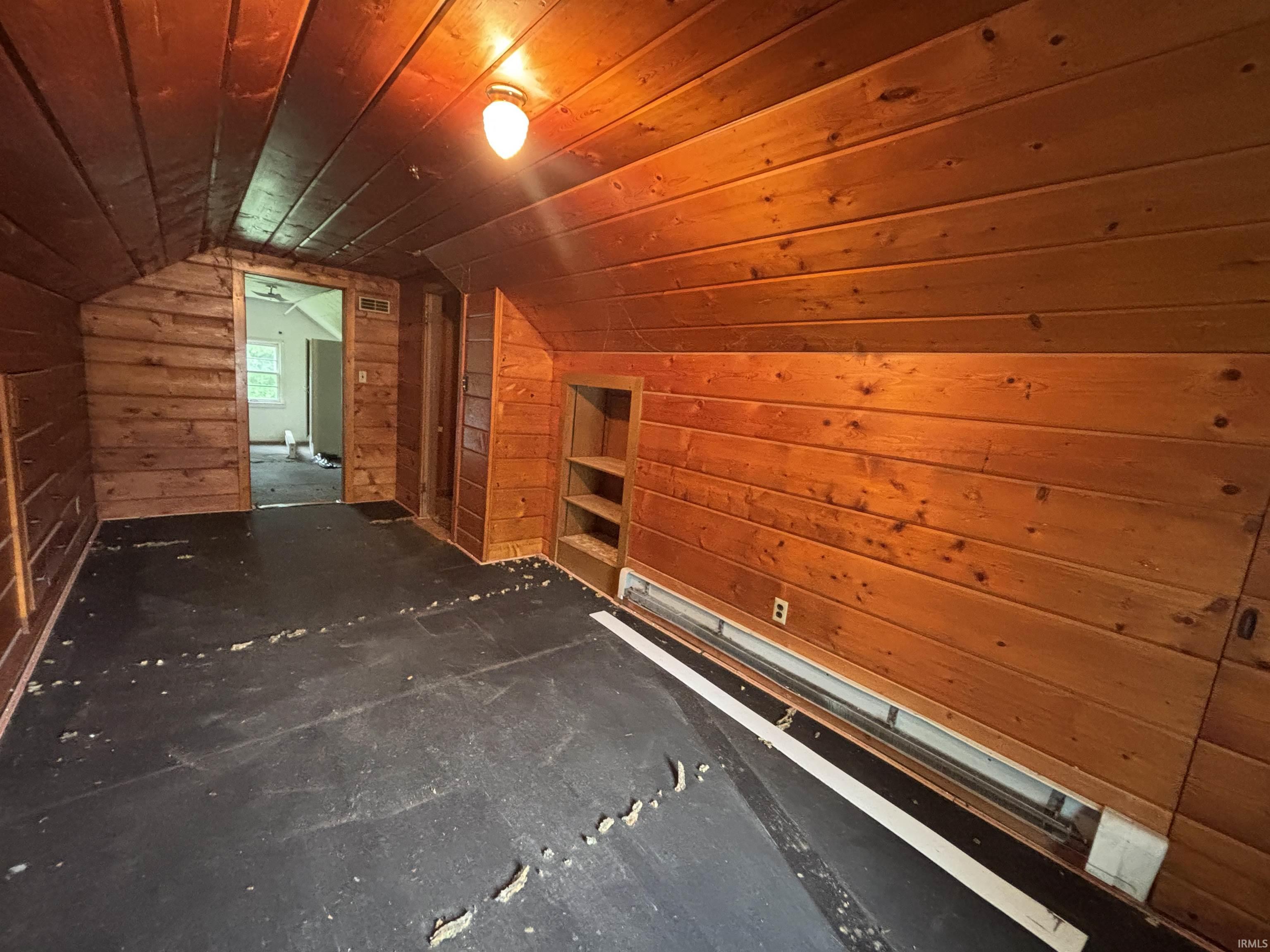 Room featuring natural wood plank walls and ceiling