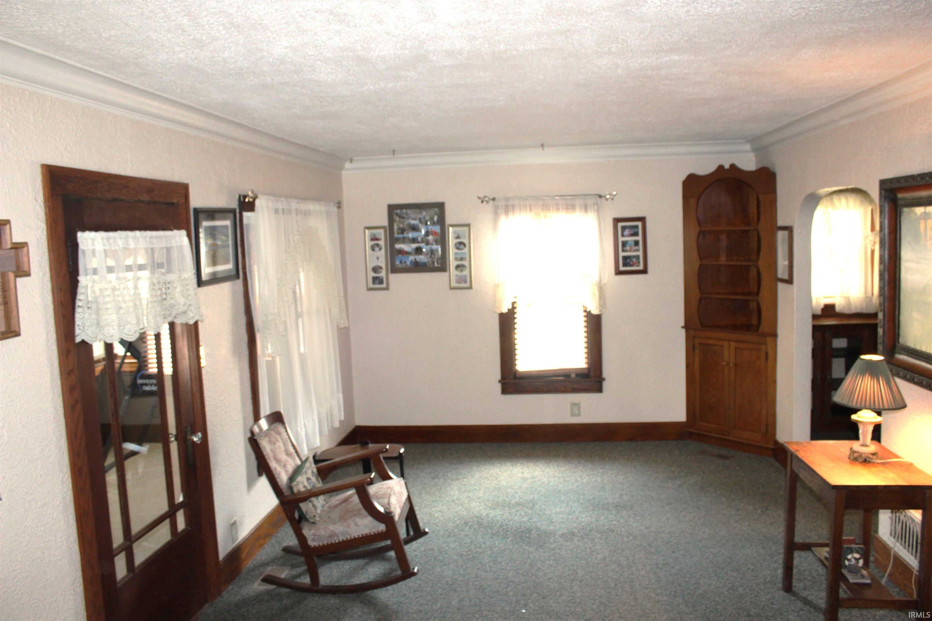 Living area featuring textured walls and crown molding