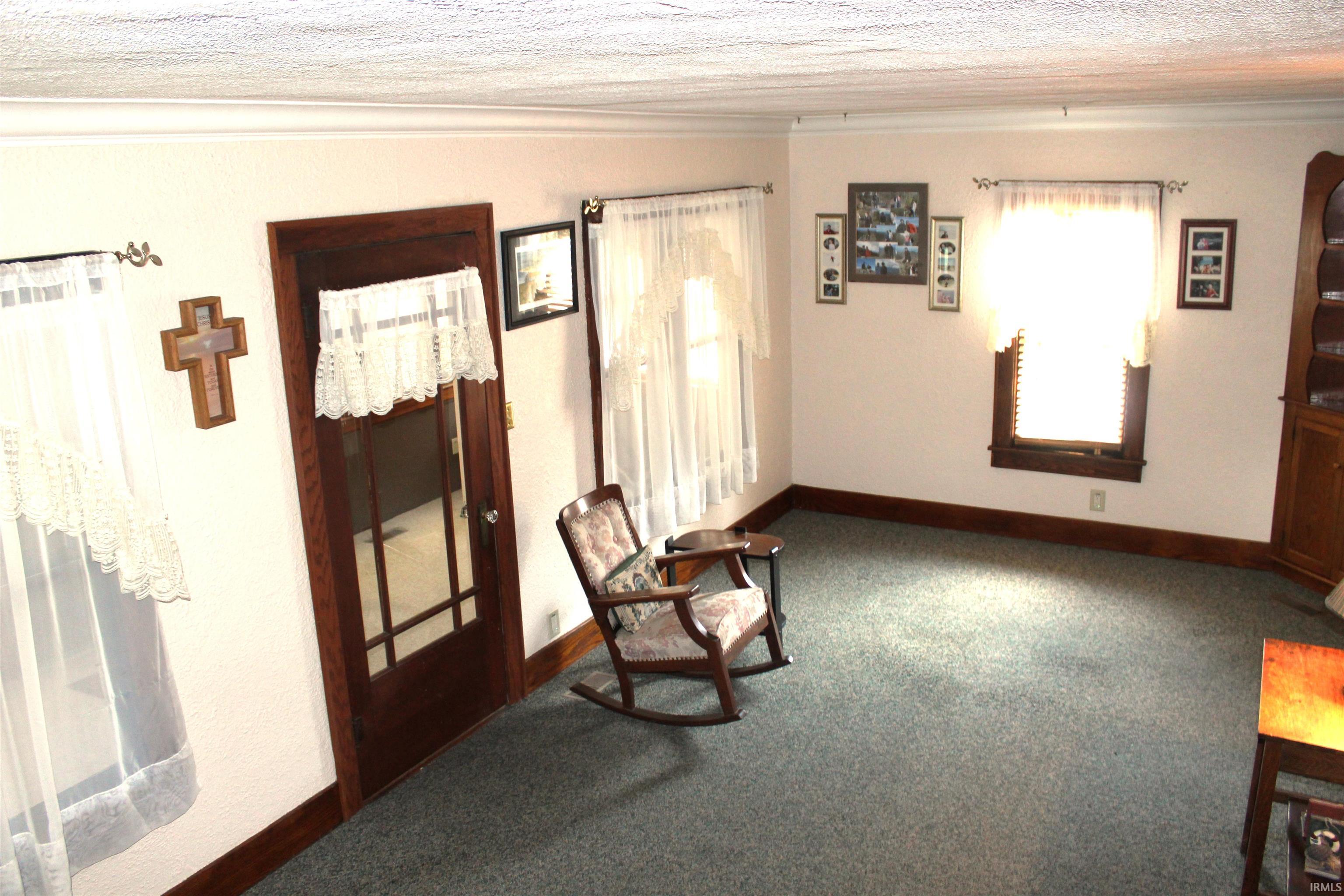 Interior space featuring carpet flooring, crown molding, and multiple windows