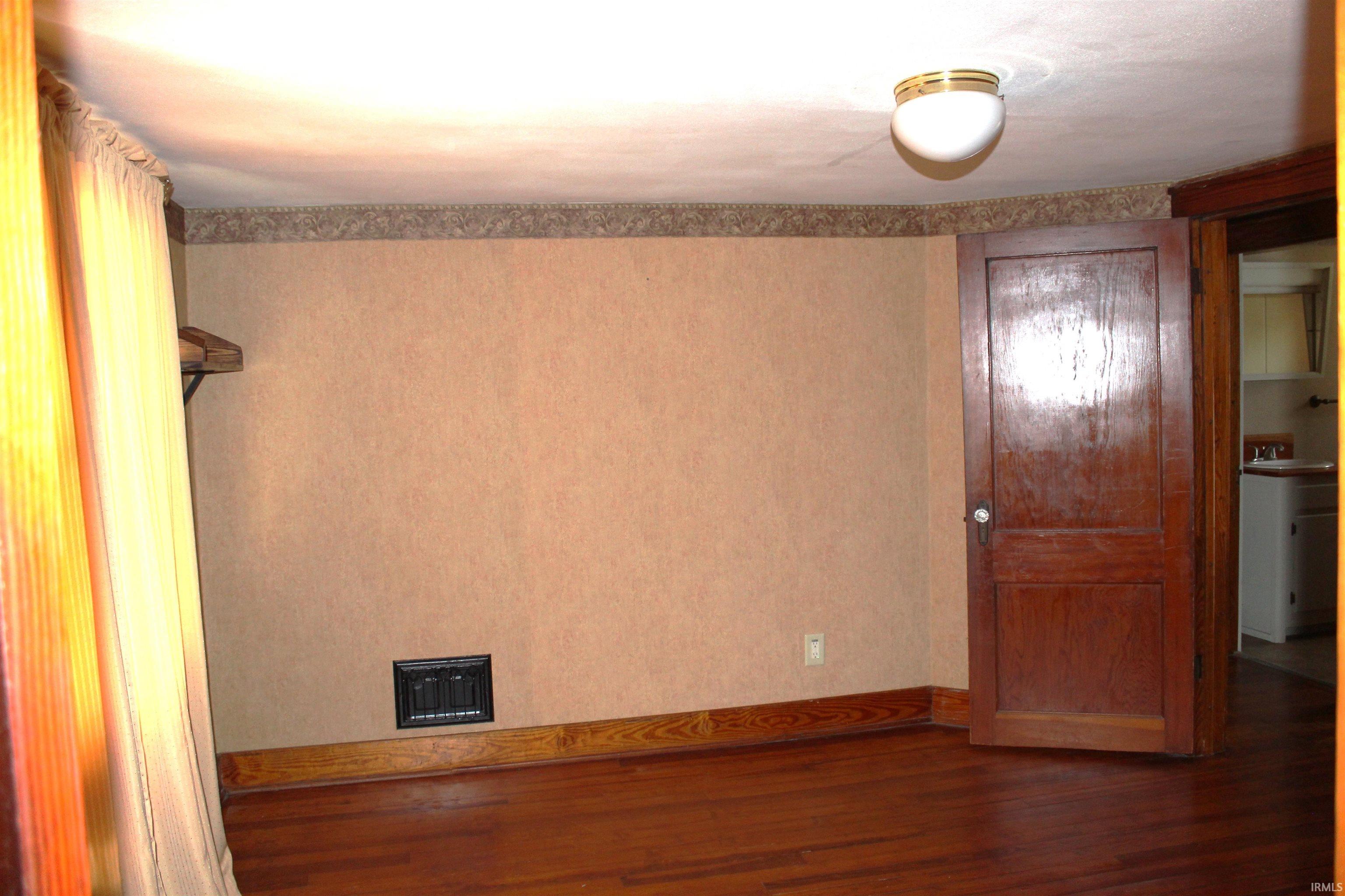 Hardwood flooring throughout, featuring a detailed baseboard trim