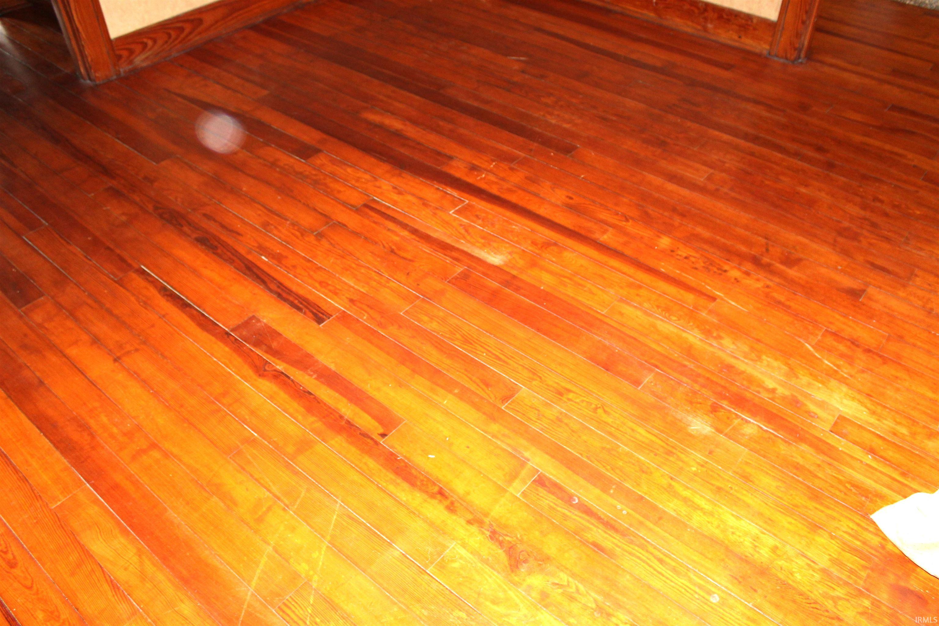 Wood-finish flooring with varying plank widths and a polished surface