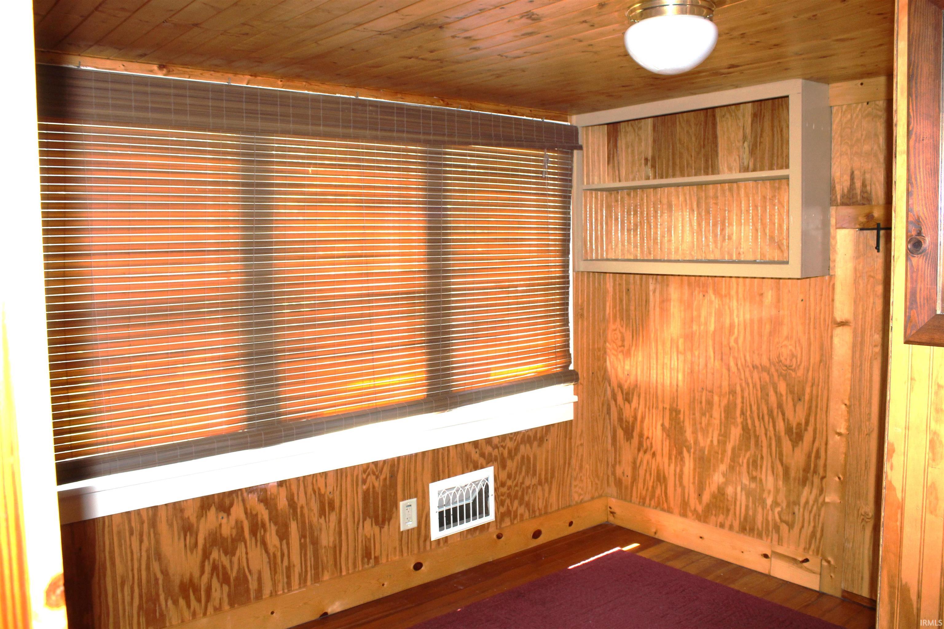 Room featuring wood-finish paneling, a wood plank ceiling, and wood-finish flooring