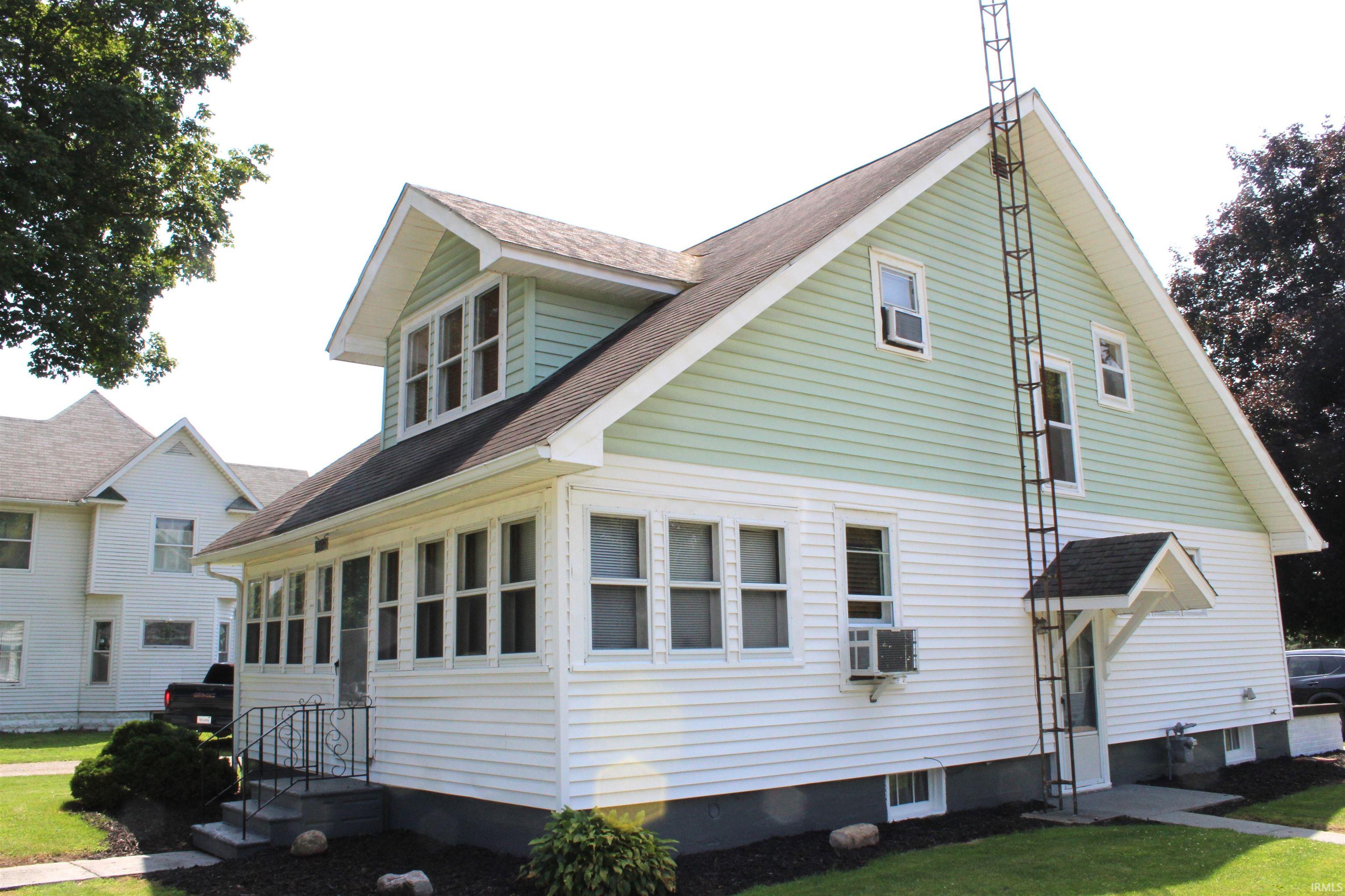 Two-story home with a light green and white siding exterior