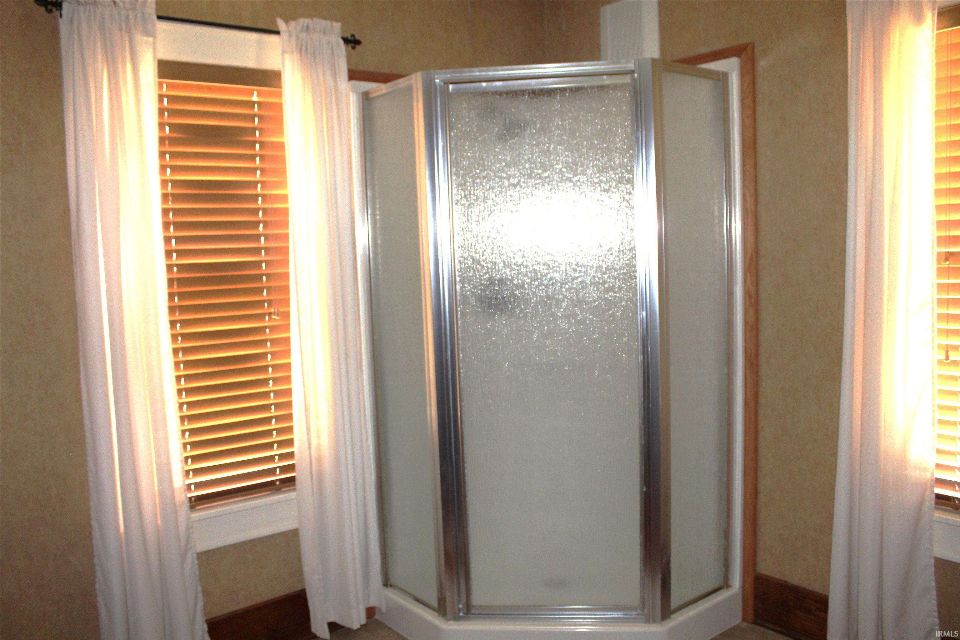 Corner shower enclosure with frosted glass panels and chrome trim
