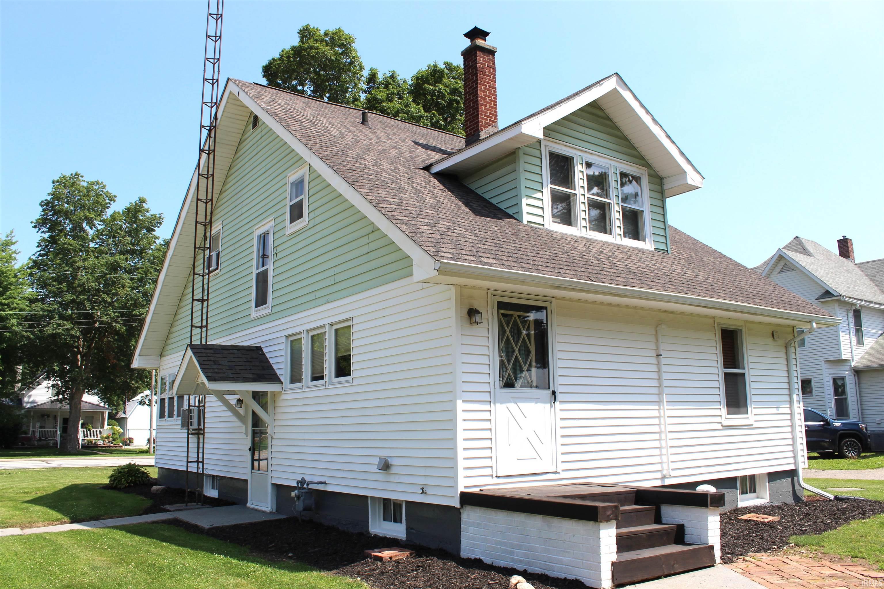 Two-story residence featuring light green siding on the upper level and white siding on the lower level