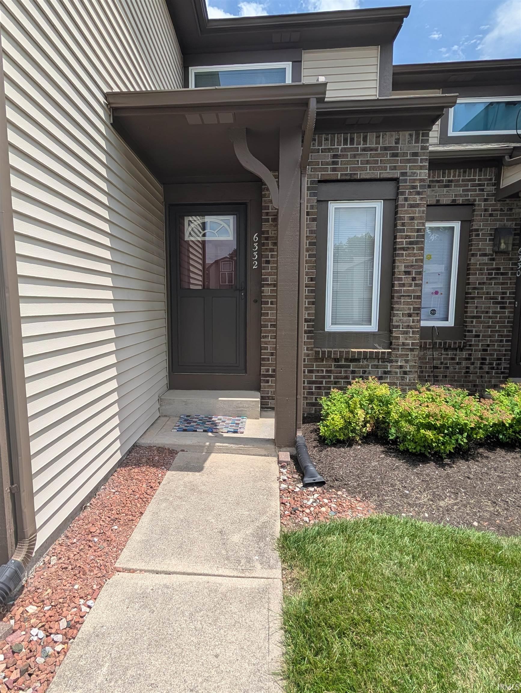Inviting entryway featuring a covered porch with a decorative support beam