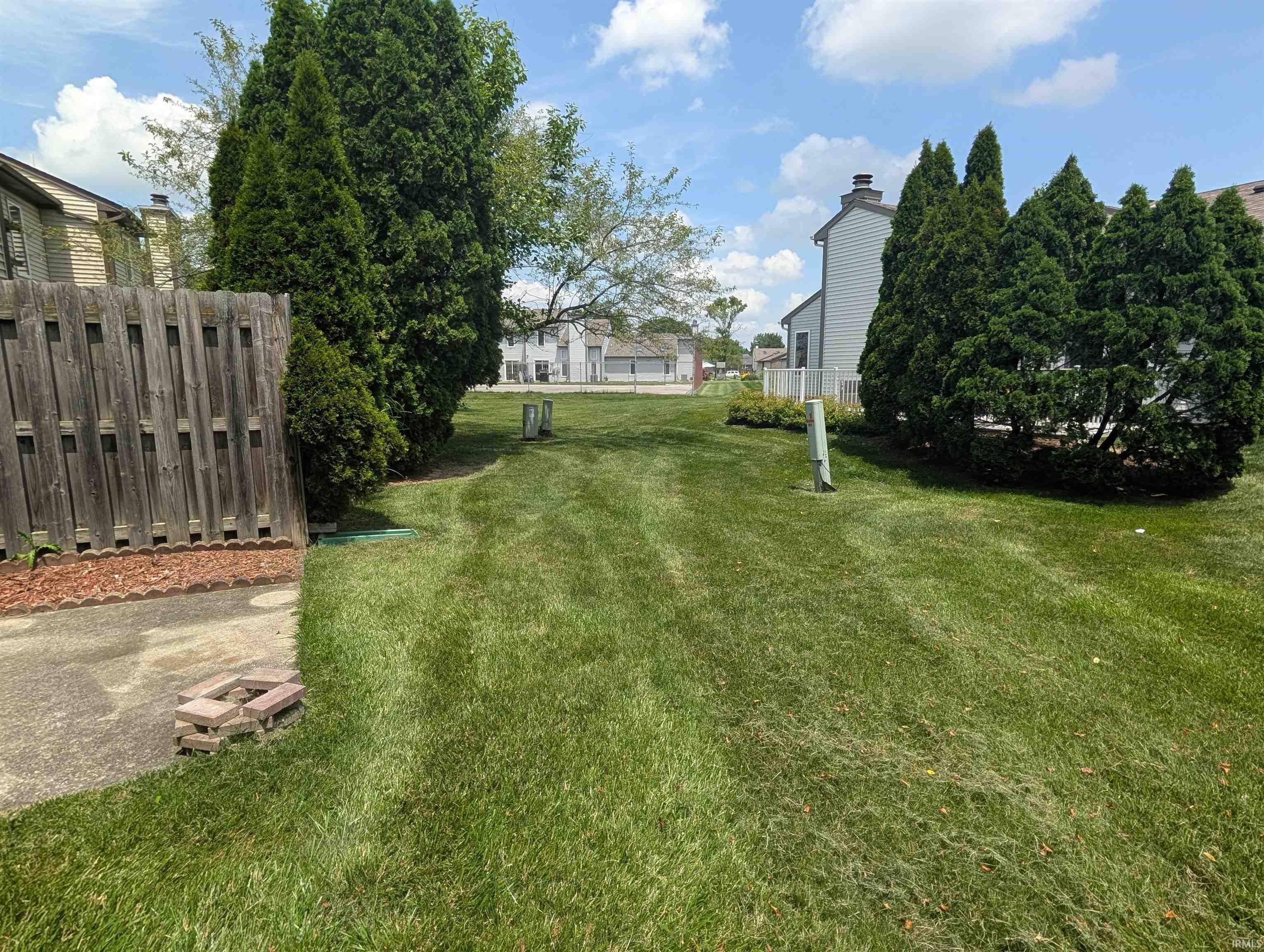 Expansive green lawn extending to mature evergreen trees