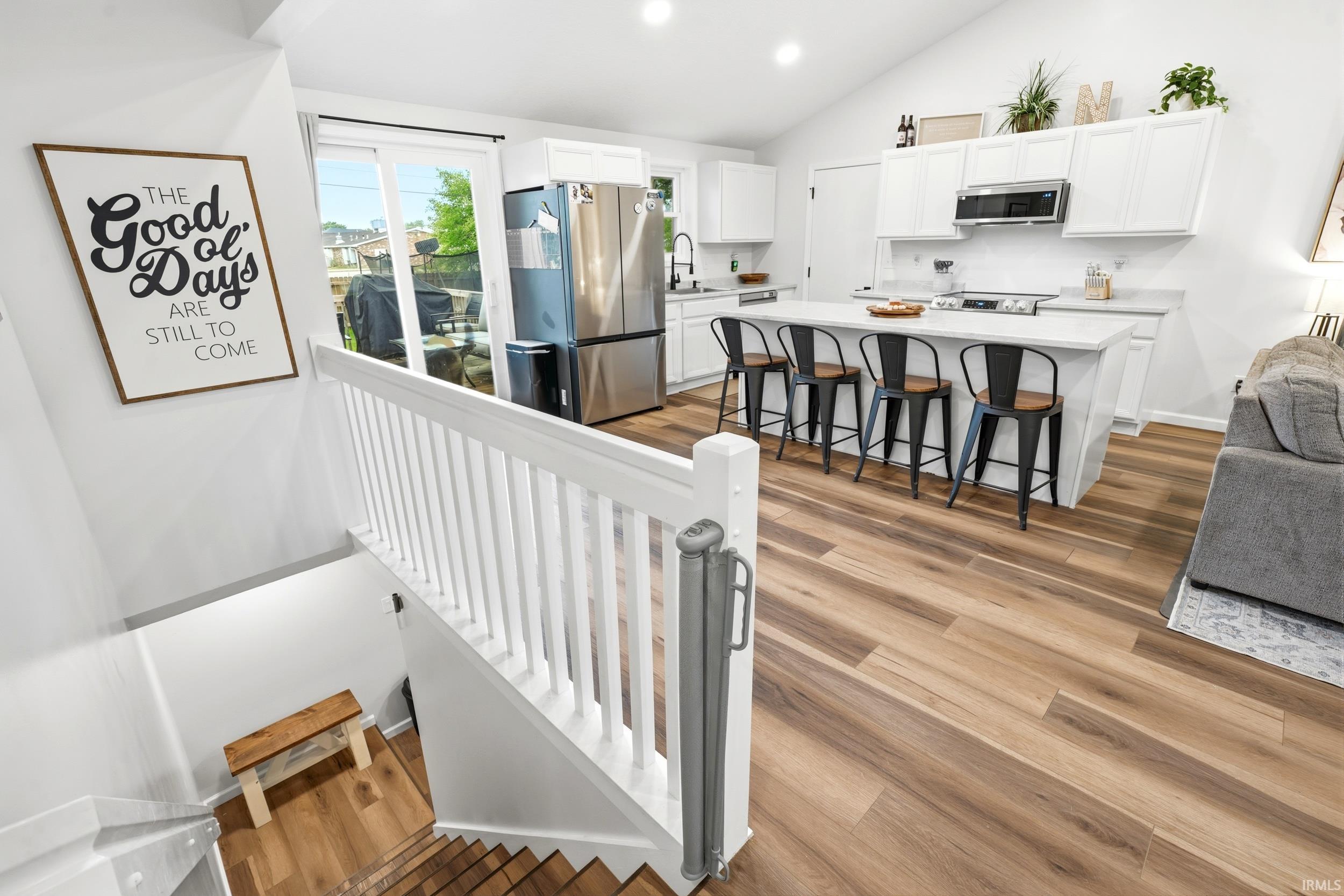 Open-concept kitchen with white cabinetry and an extended island featuring a light-toned countertop