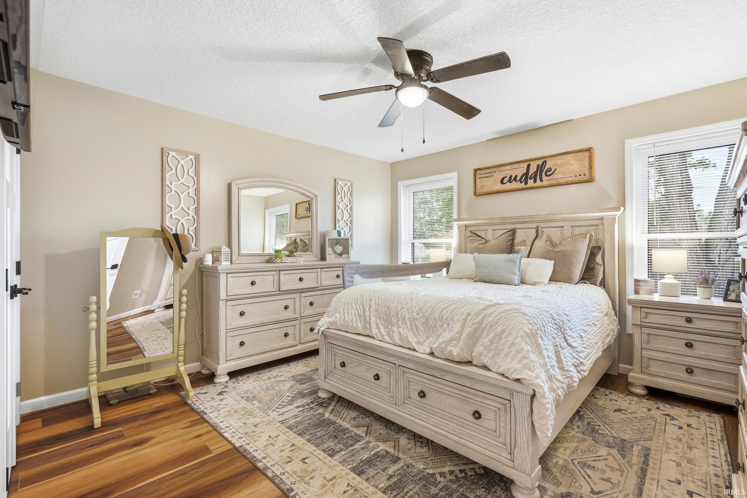 Spacious bedroom with wood-finish flooring and neutral wall tones