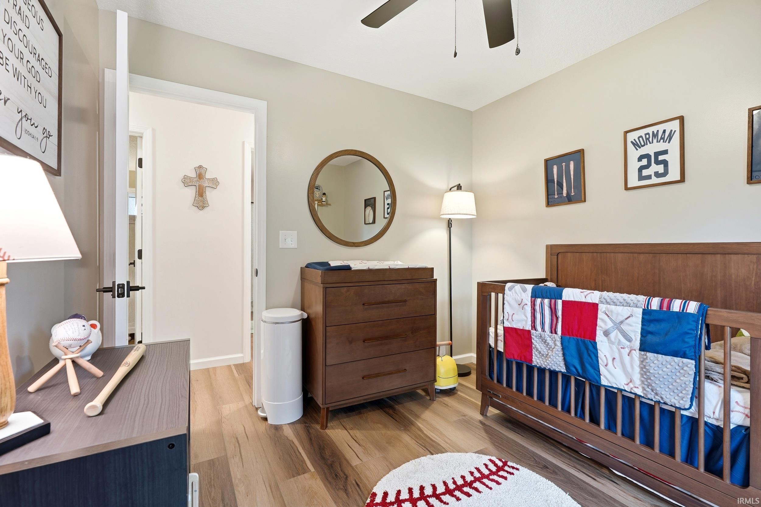 Bedroom featuring wood-finish flooring, a ceiling fan, and painted walls