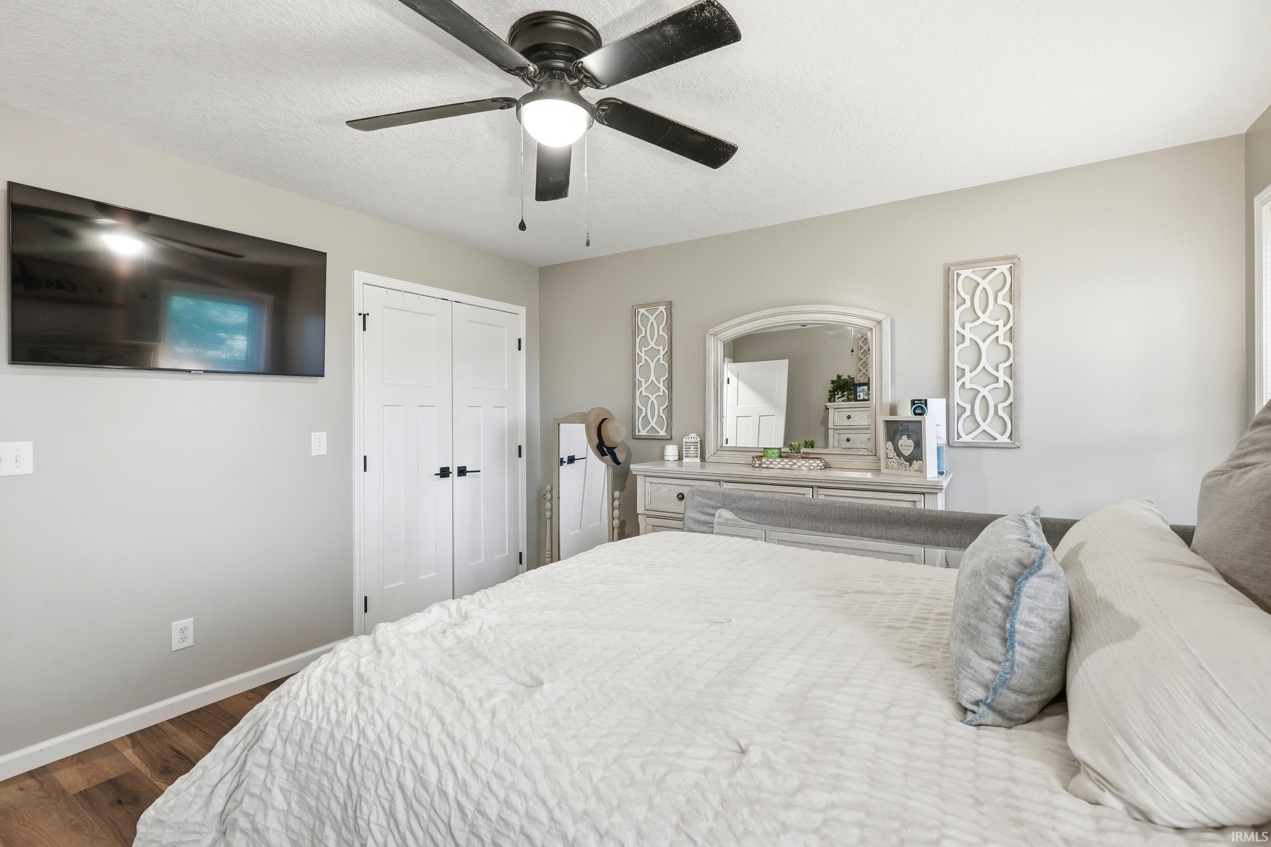 Bedroom featuring wood-finish flooring, light gray wall paint, and a ceiling fan with integrated lighting