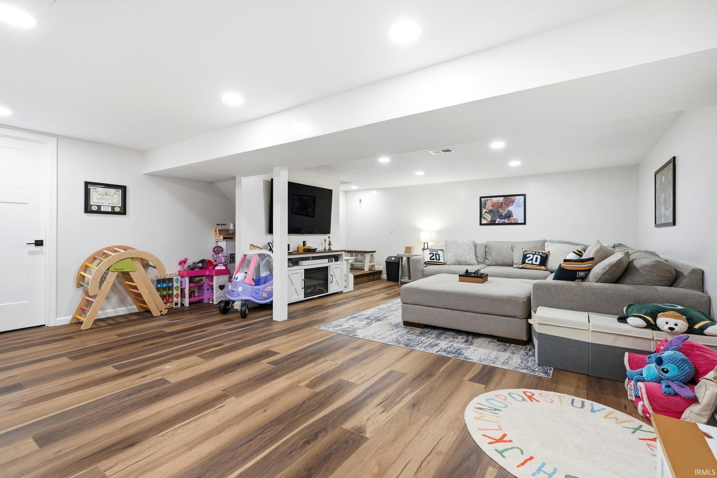 Spacious lower-level area featuring recessed lighting and durable wood-finish flooring