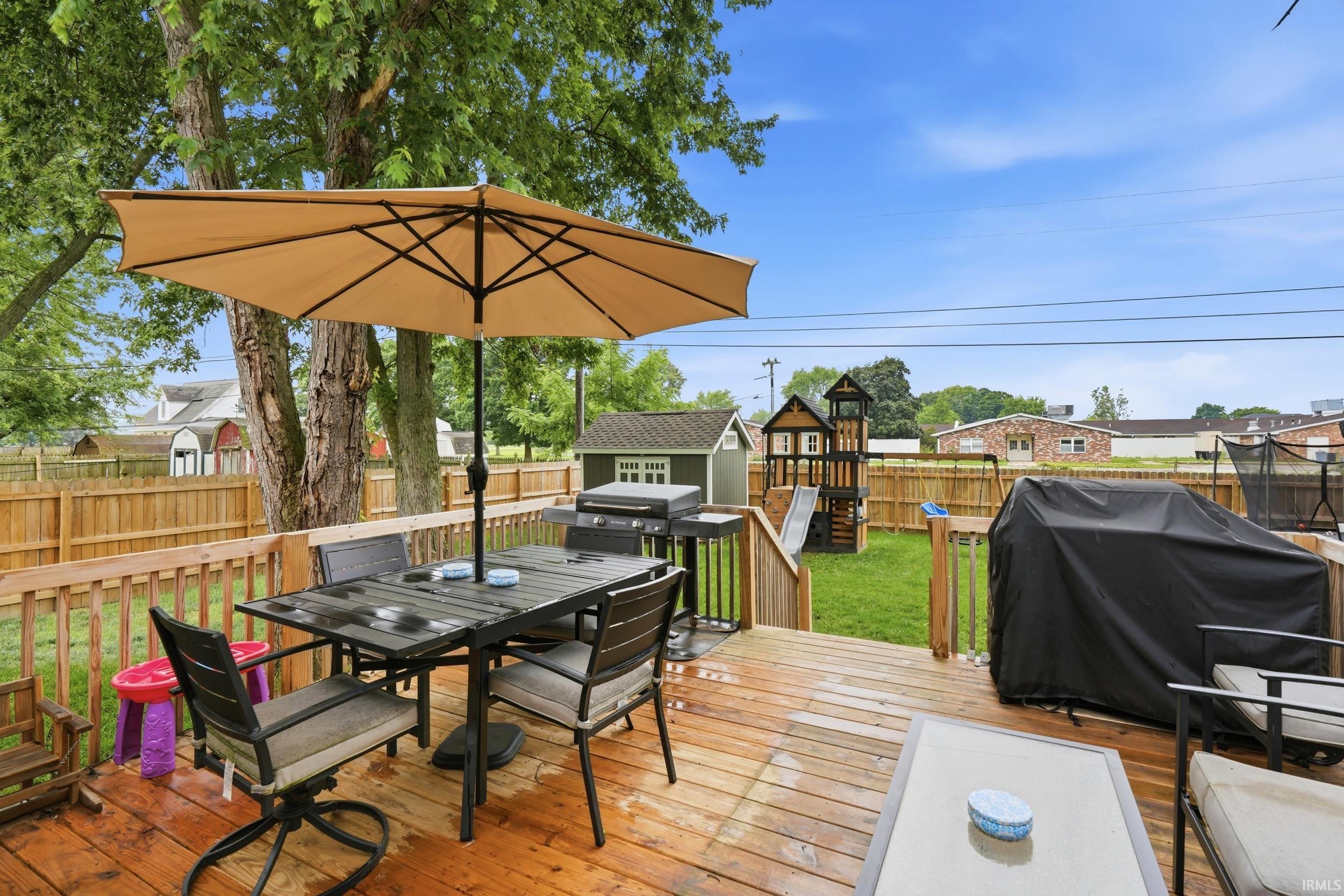 Spacious outdoor wood deck with a privacy fence