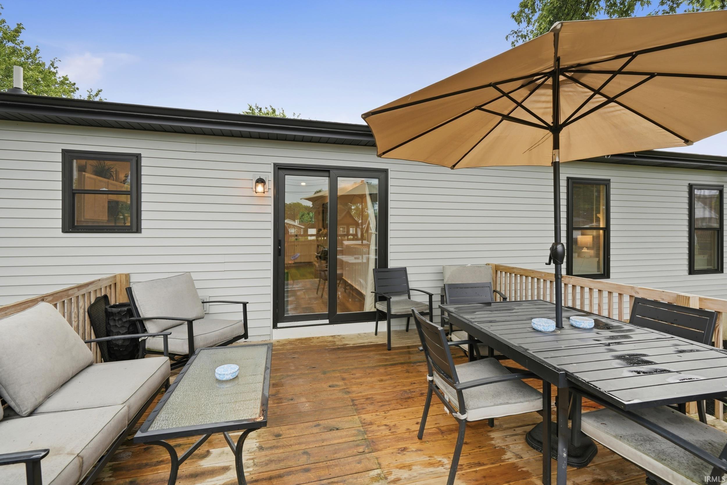 Spacious wood-finish deck with a wood railing and light-colored siding