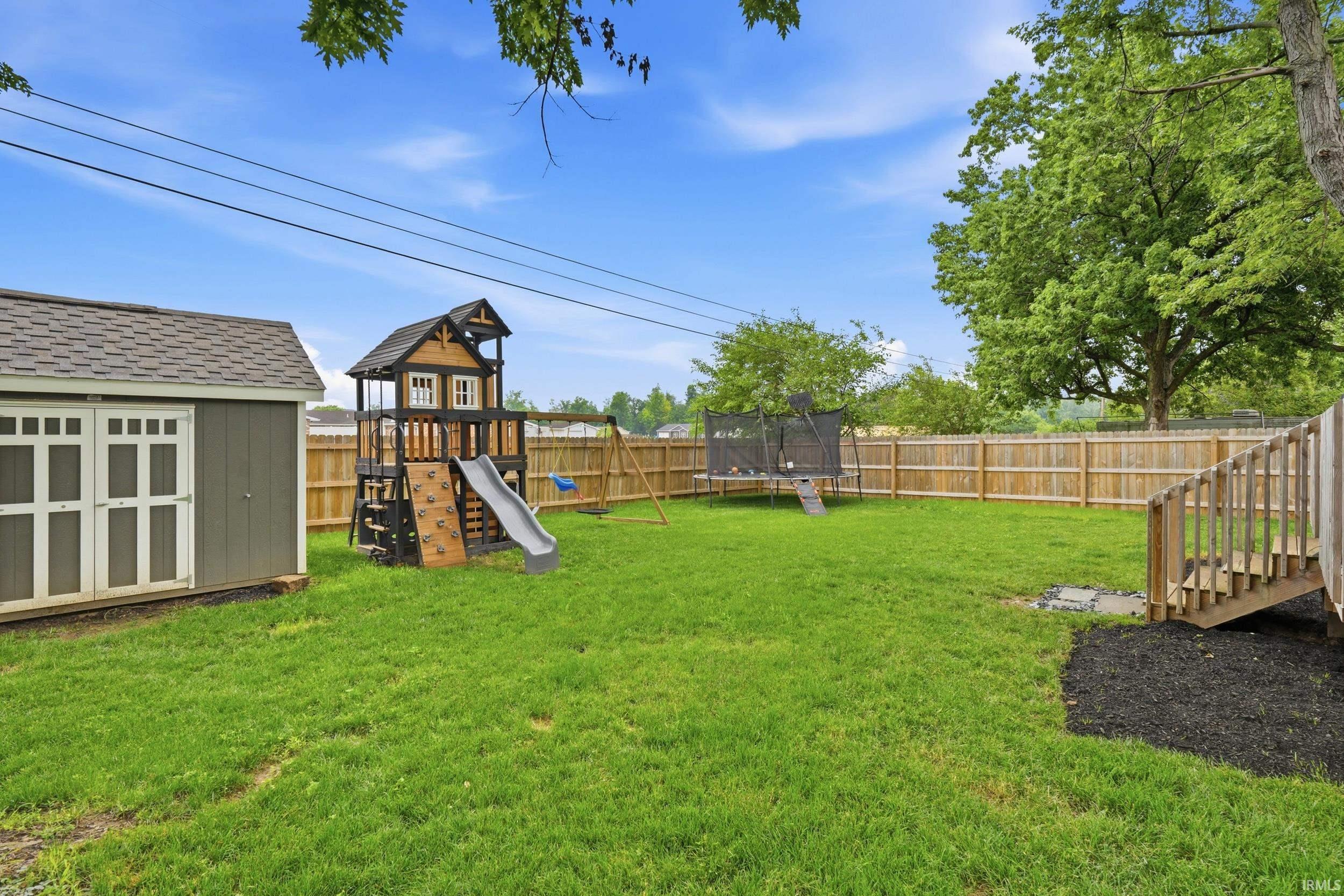 Expansive green lawn with a wood privacy fence