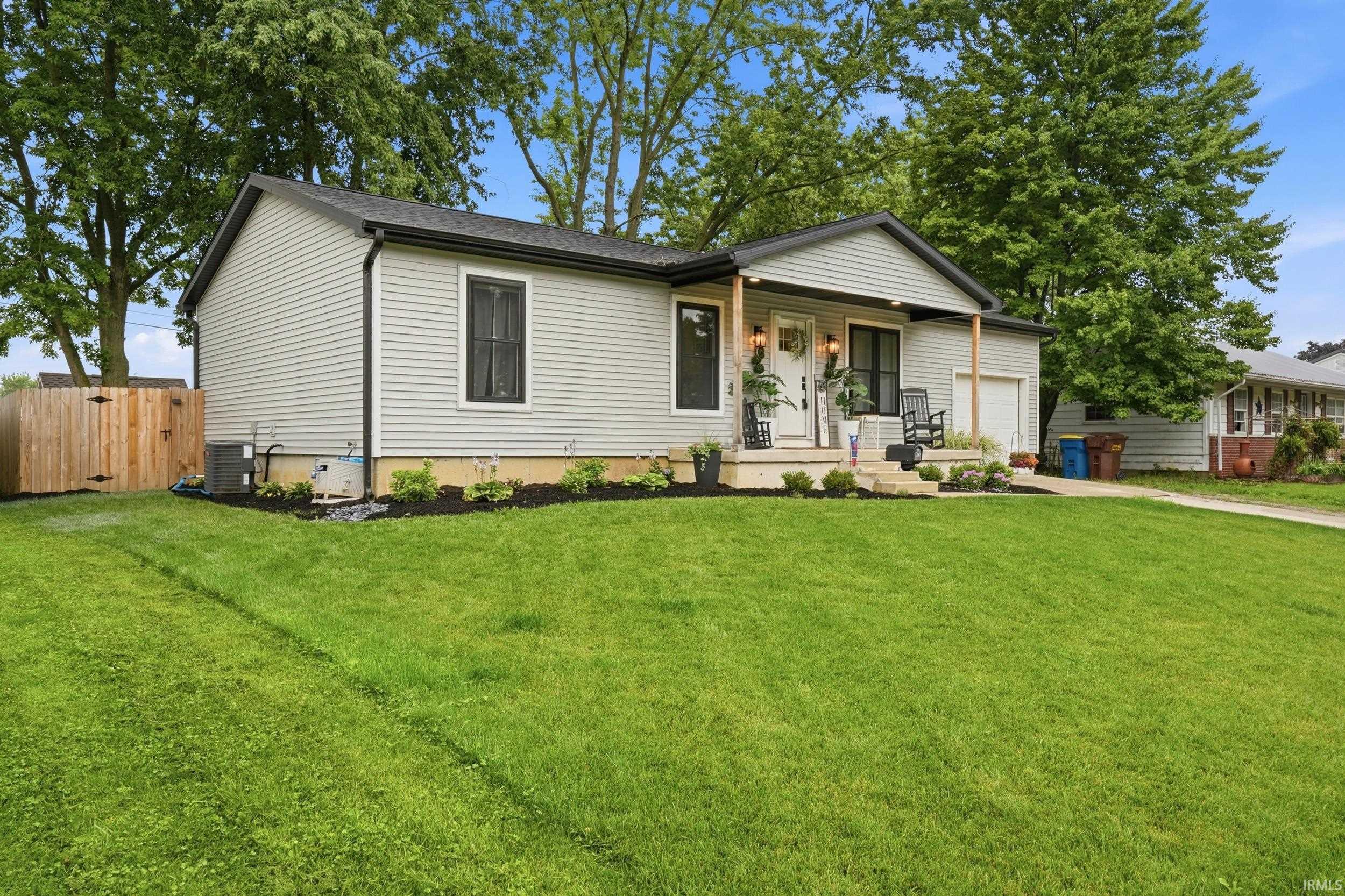 Contemporary ranch-style home featuring light gray siding and a dark roof