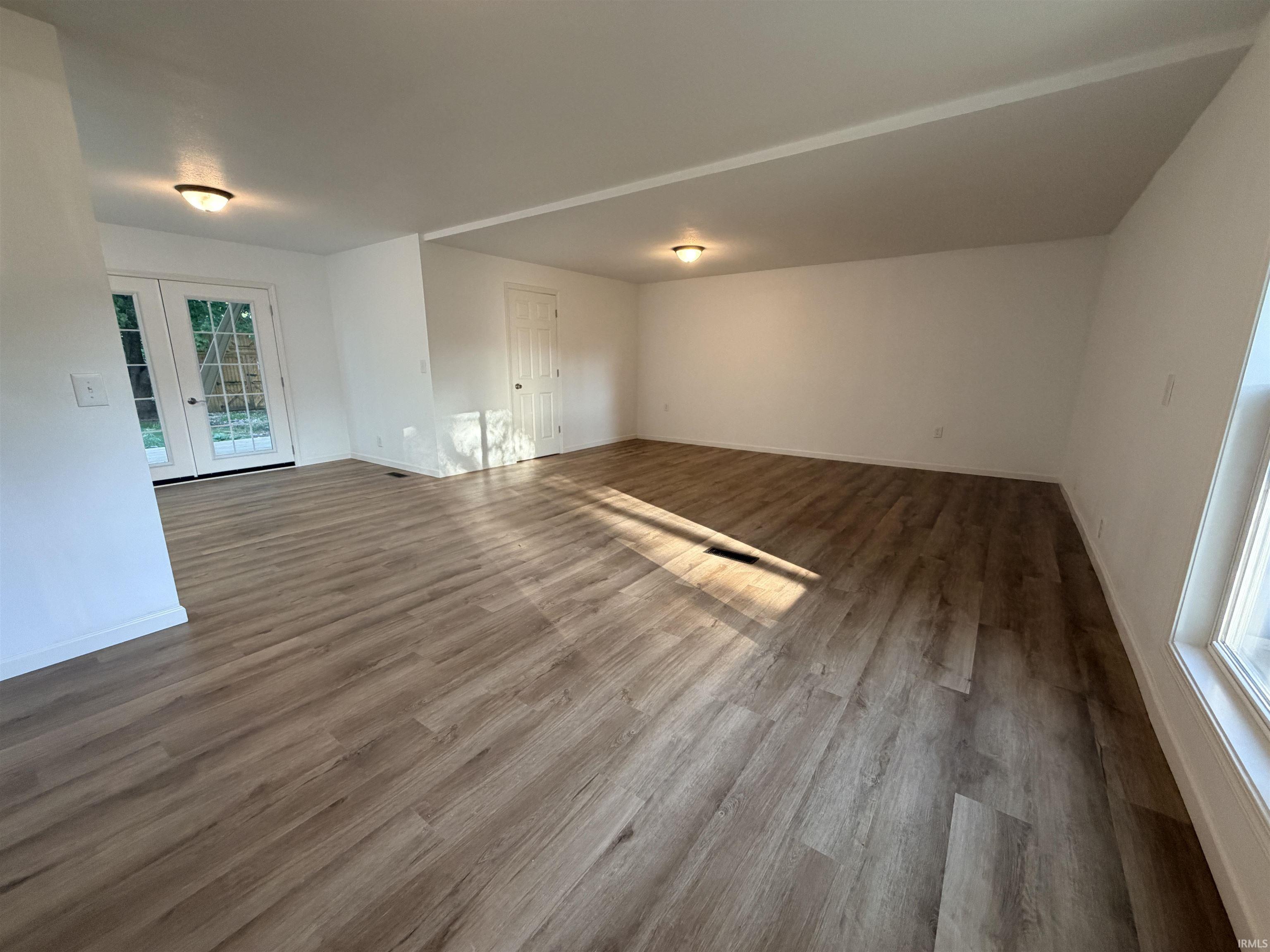 Open-concept interior featuring wood-finish flooring, white walls, and recessed lighting