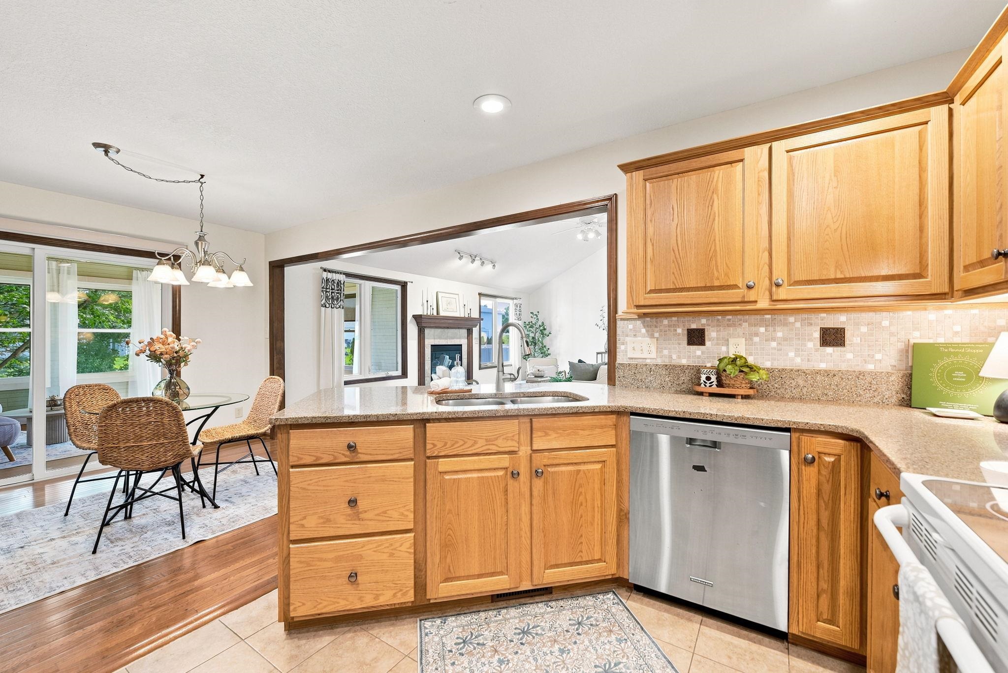 Kitchen with natural wood cabinetry, light-toned countertops, and a tiled backsplash
