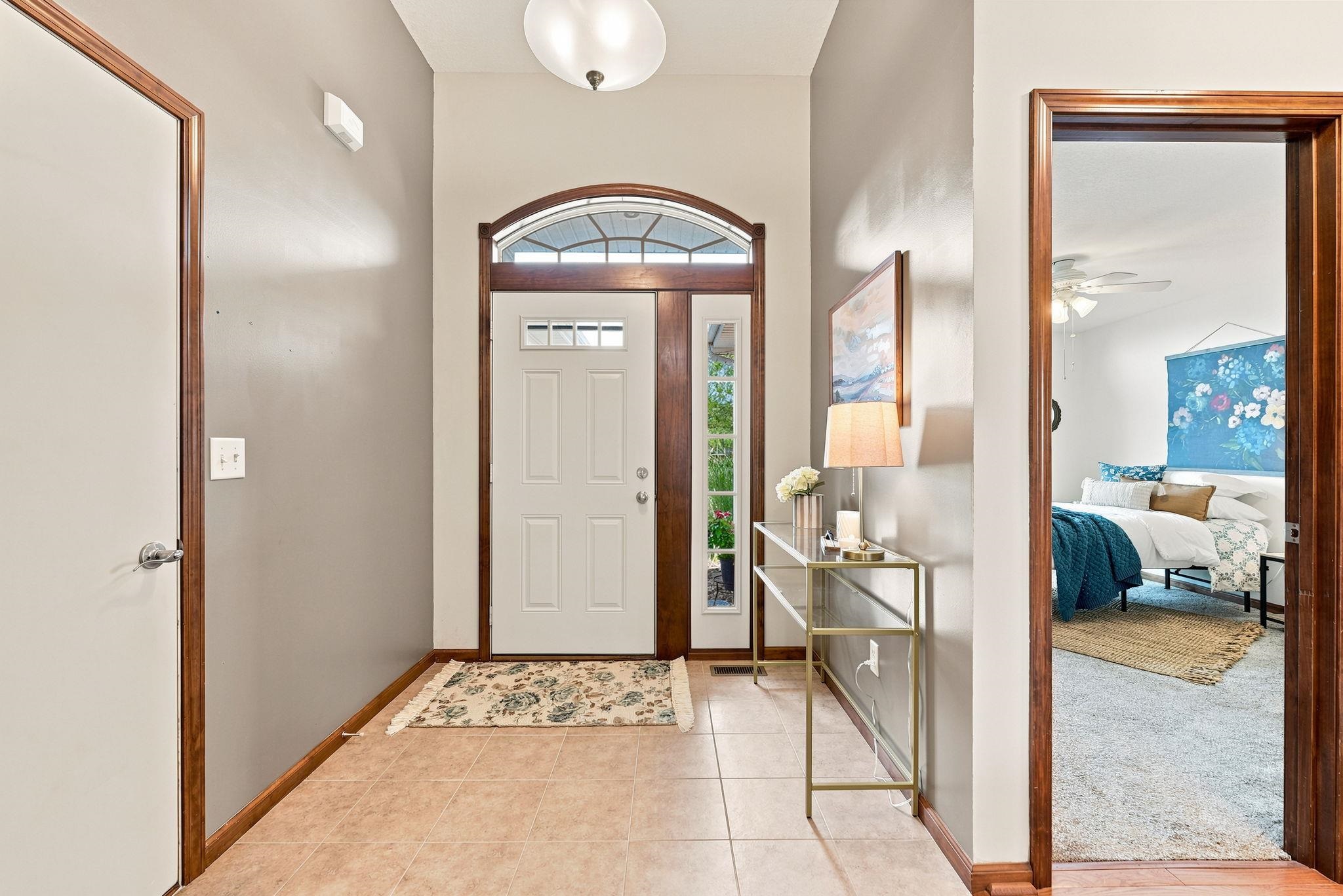Entryway featuring a solid panel door with upper lites, an arched transom window, and a sidelite