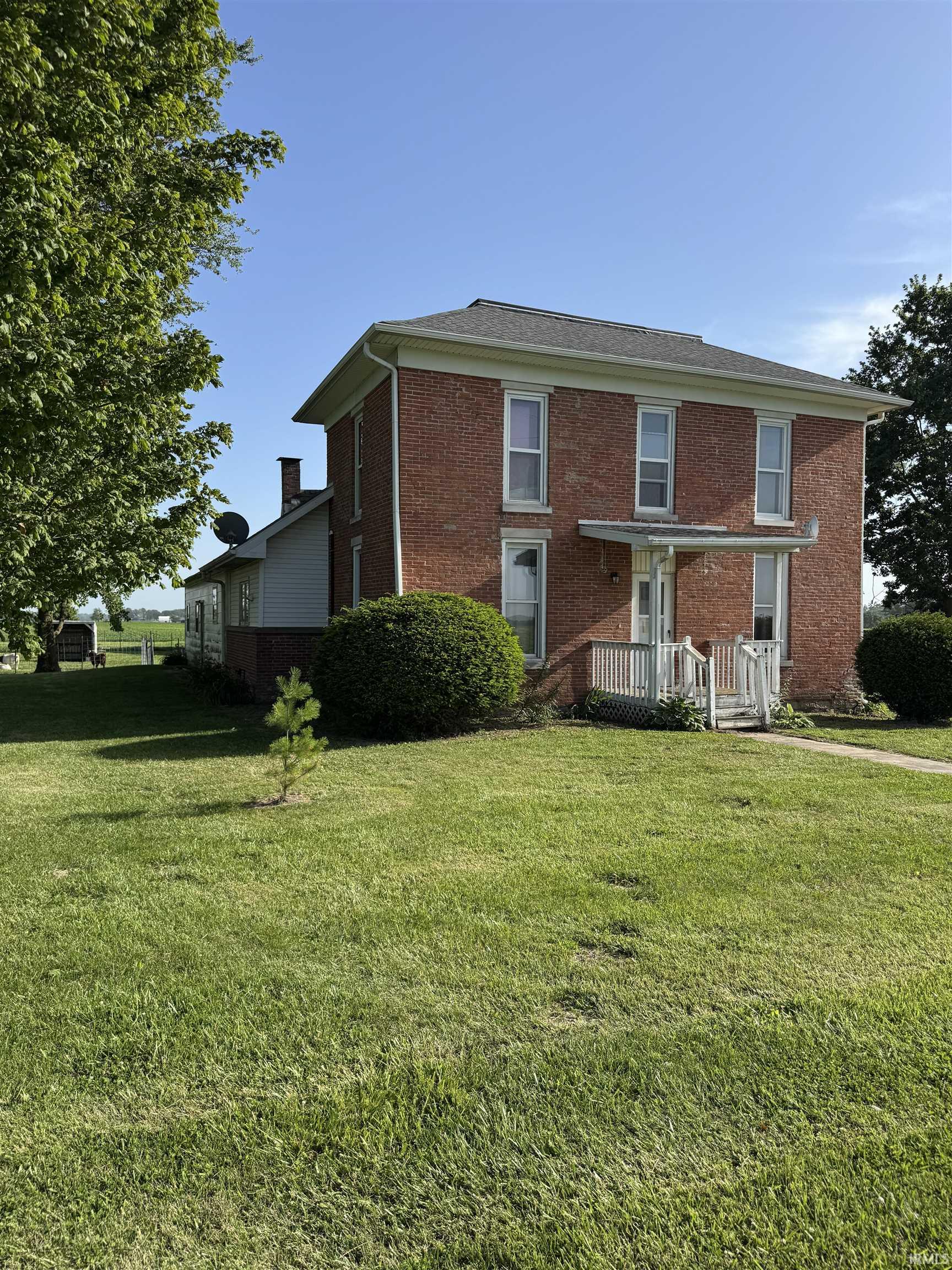 Brick exterior with white window frames and a contrasting dark roof
