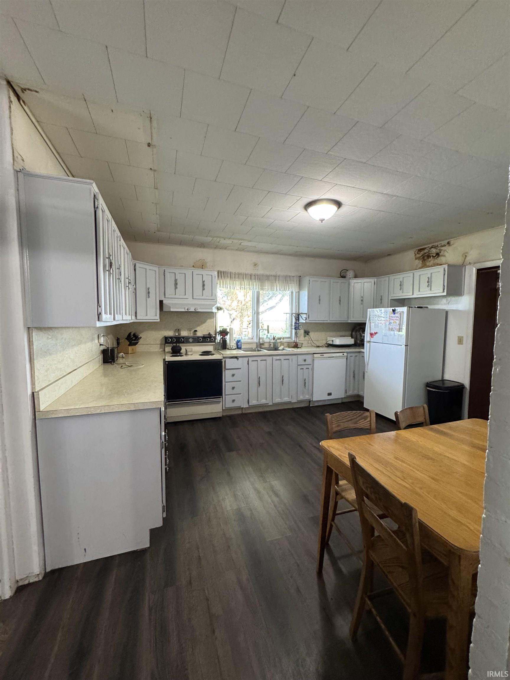 Kitchen featuring white cabinetry, light-toned countertops, and wood-finish flooring