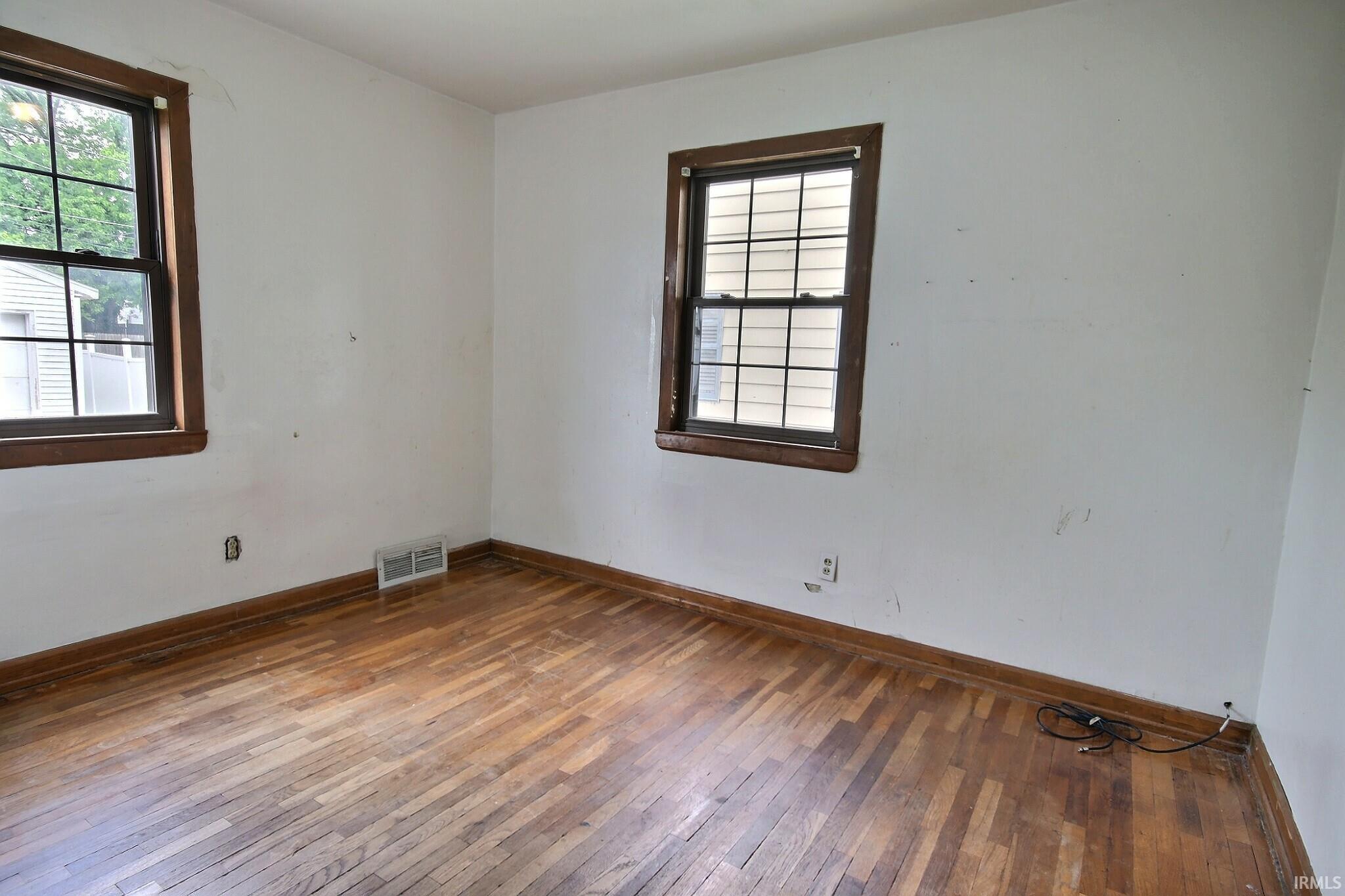 Hardwood flooring with a natural finish, complemented by dark wood trim around windows and baseboards