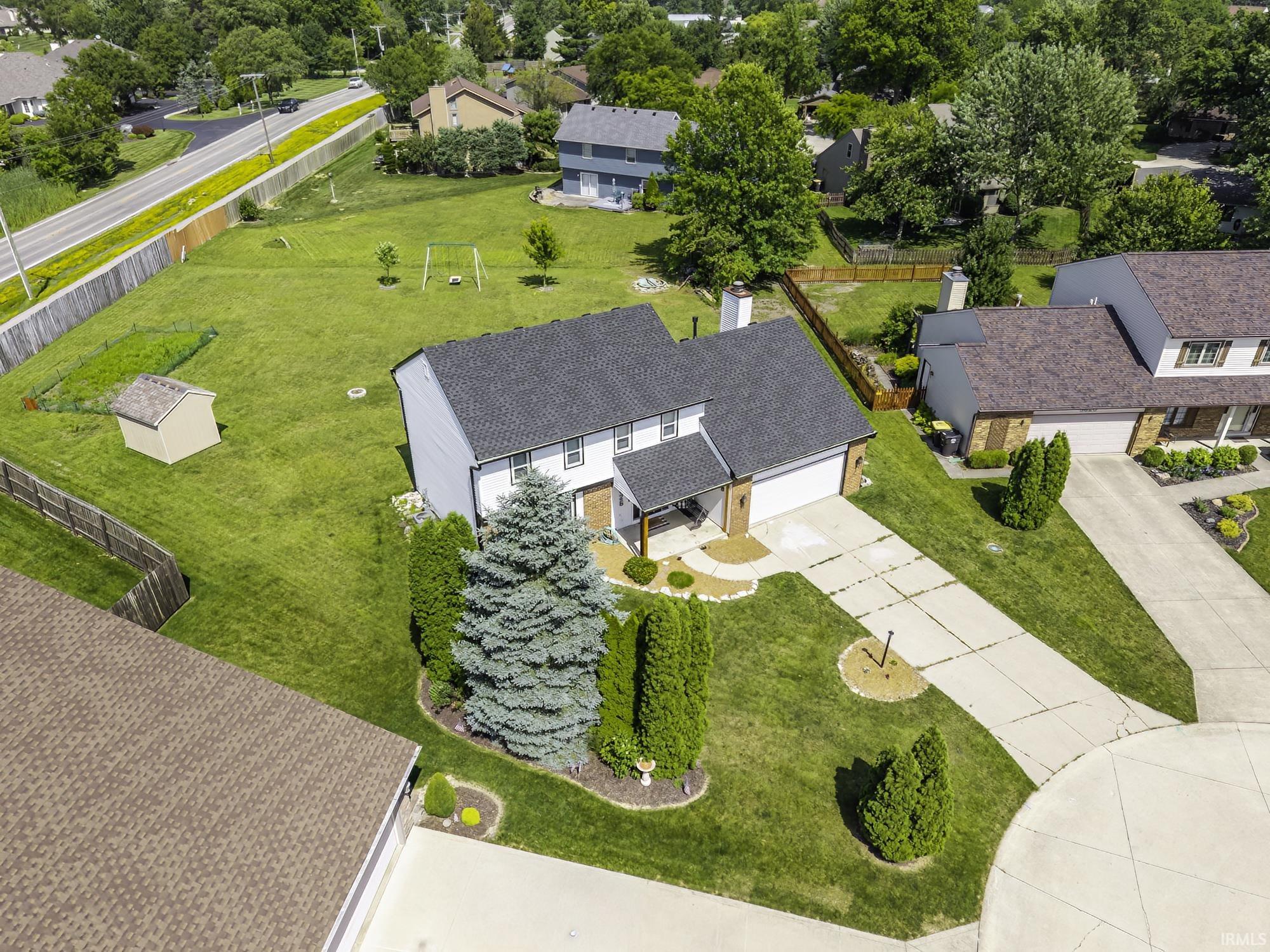Two-story residence with a dark shingle roof, attached two-car garage, and a covered front entry