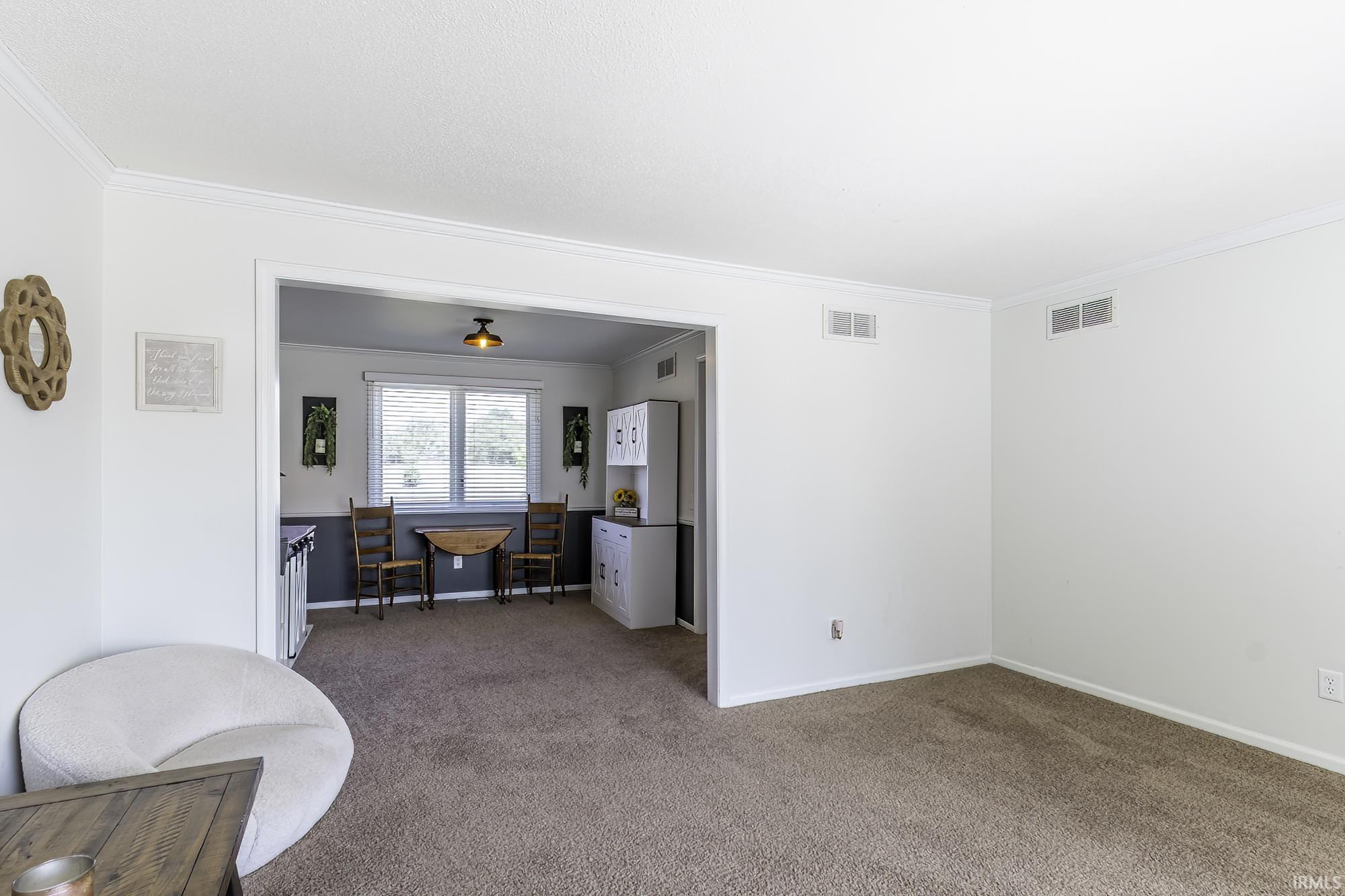 Broadloom carpeting with light neutral walls and crown molding