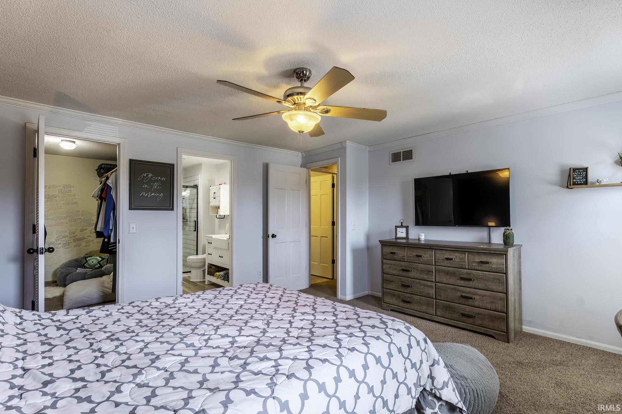 Bedroom featuring carpet flooring, a ceiling fan with integrated lighting, white baseboards, and crown molding