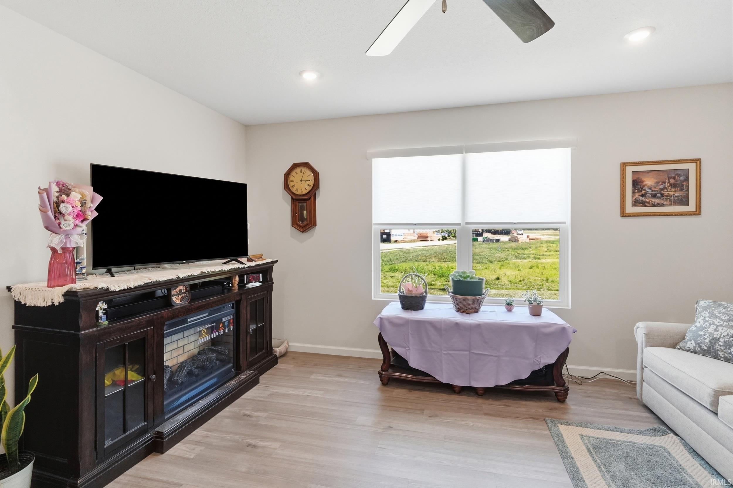 Spacious room featuring wood-finish flooring and a ceiling fan